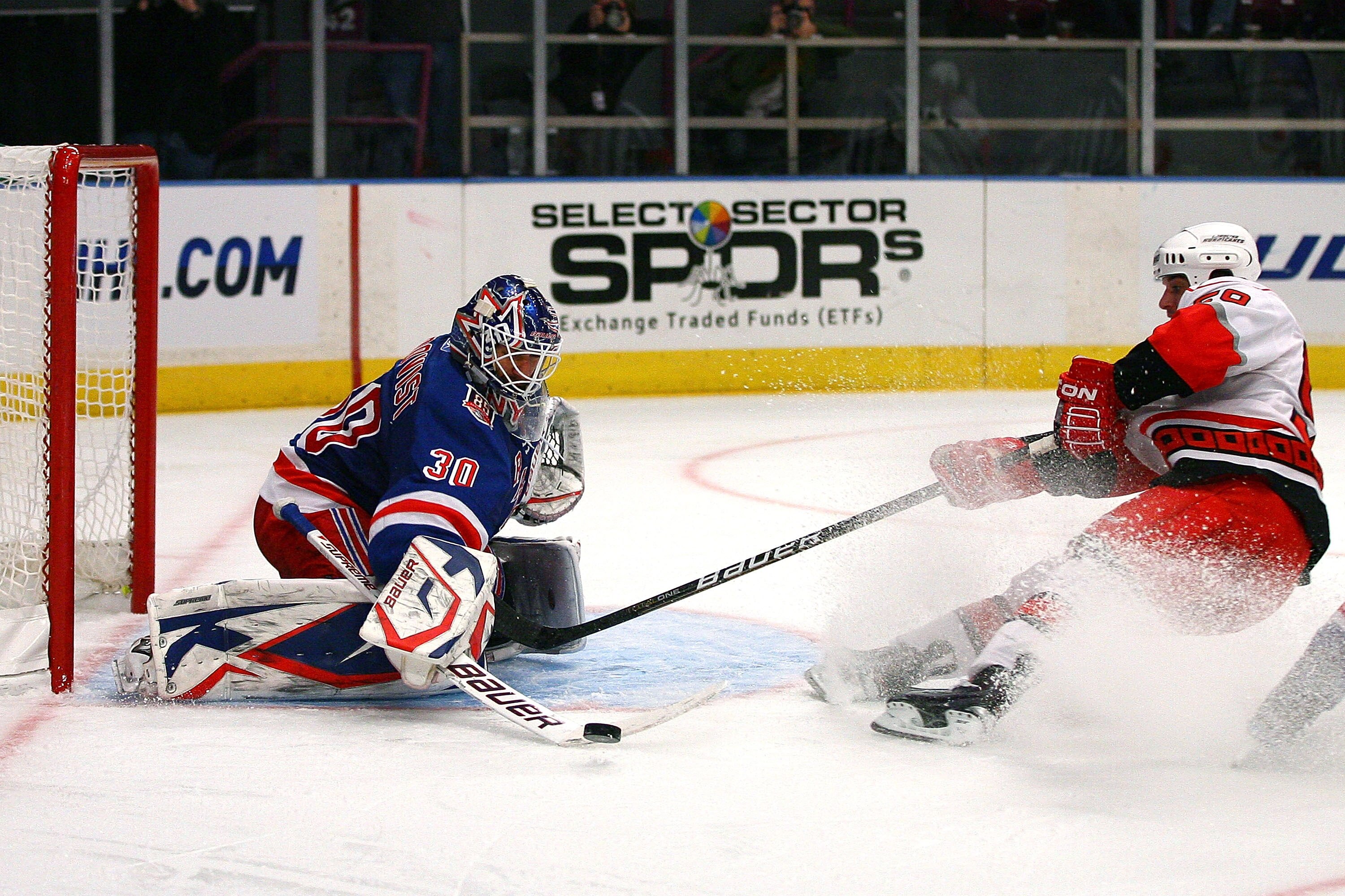 NEW YORK - OCTOBER 29:  Henrik Lundqvist #30 of the New York Rangers blocks a shot from Chad LaRose #59 of the Carolina Hurricanes on October 29, 2010 at Madison Square Garden in New York City, New York. The Hurricanes defeated the Rangers 4 - 3. (Photo b