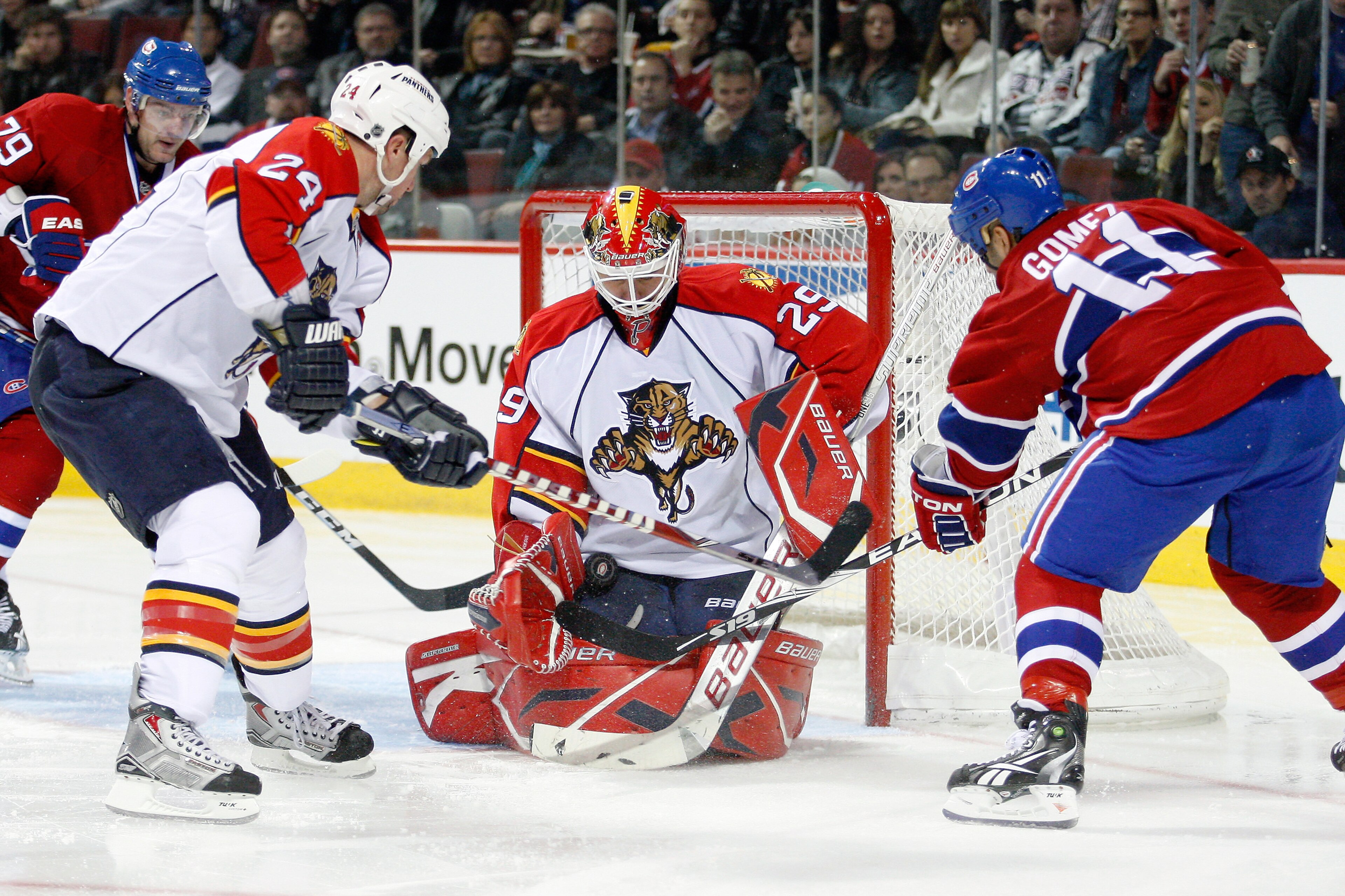 MONTREAL- OCTOBER 30:  Tomas Vokoun #29 of the Florida Panthers stops the puck in front of team mate Bryan McCabe #24 and Scott Gomez #11 of the Montreal Canadiens during the NHL game at the Bell Centre on October 30, 2010 in Montreal, Quebec, Canada.  (P