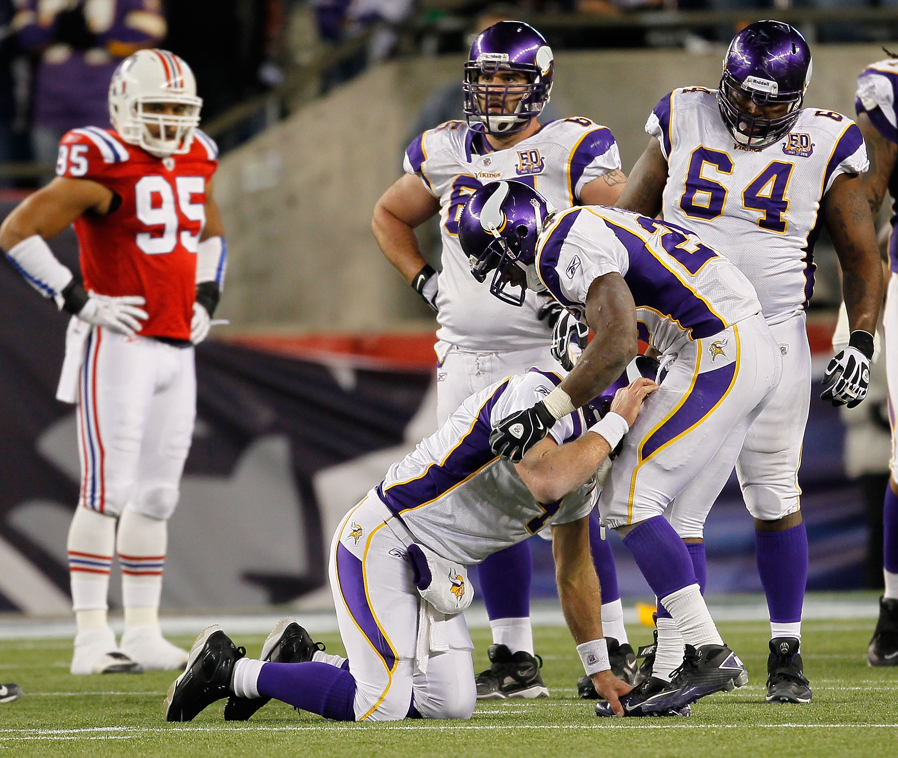 FOXBORO, MA - OCTOBER 31:  Brett Favre #4 of the Minnesota Vikings is aided by teammate Adrian Peterson #28 after Favre was hit by Myron Pryor #91 of the New England Patriots in the fourth quarter at Gillette Stadium on October 31, 2010 in Foxboro, Massac