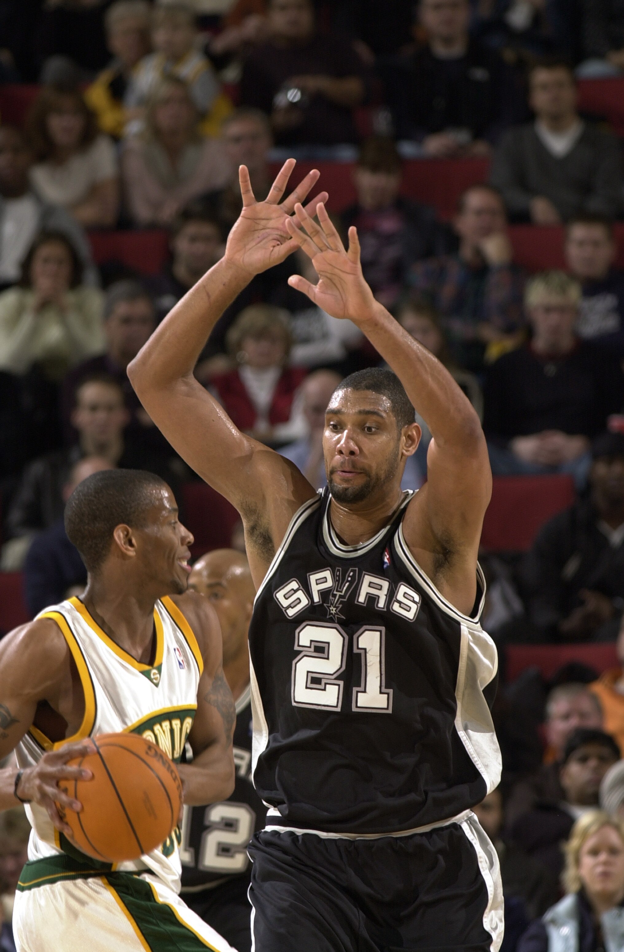 SEATTLE - DECEMBER 19:  Ronald Murray #22 of the Seattle Sonics looks to pass over Tim Duncan #21 of the San Antonio Spurs during the game on December 19, 2003 at Key Arena in Seattle, Washington.  The Spurs won 87-73.   NOTE TO USER: User expressly ackno