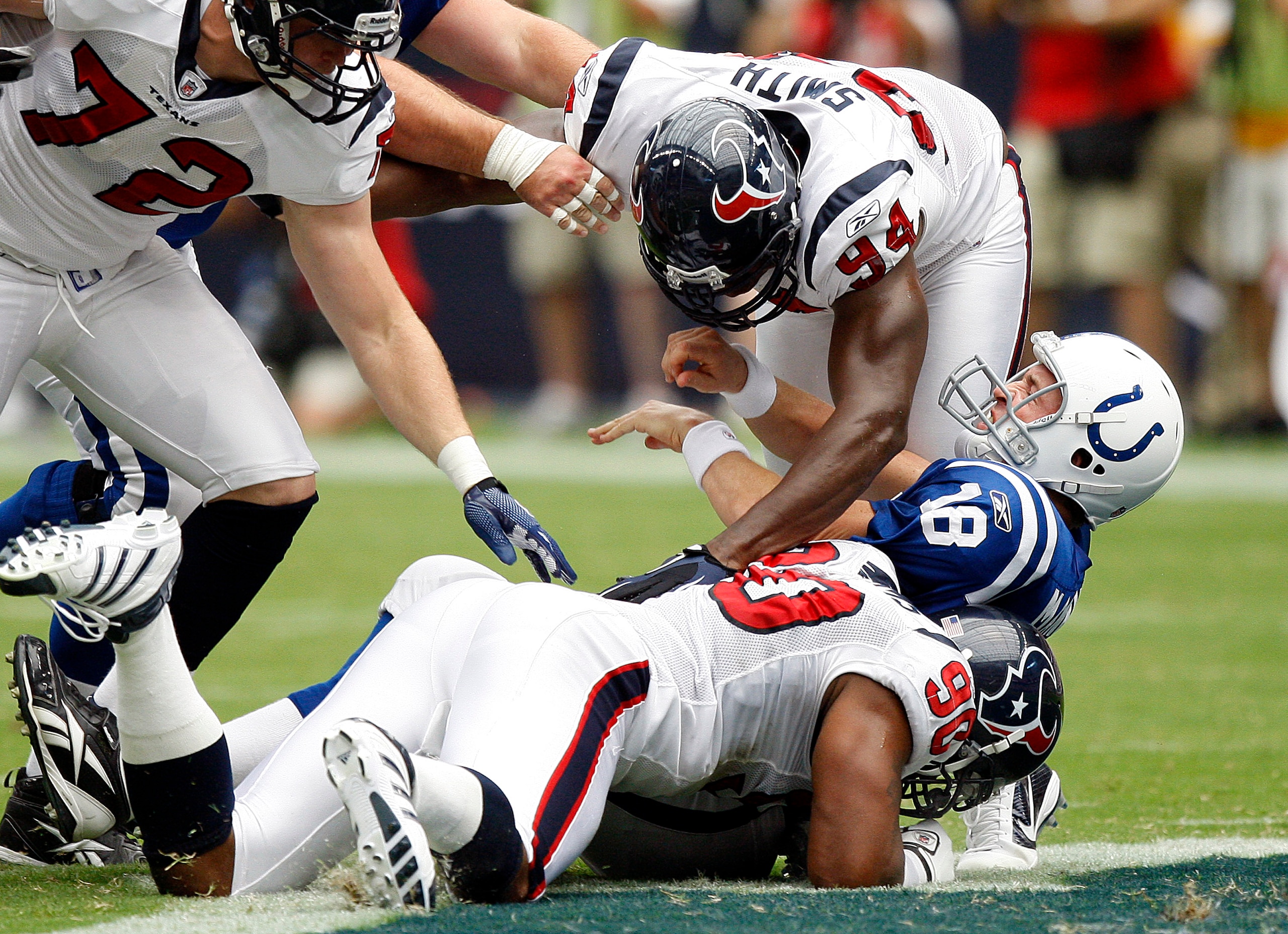 HOUSTON - SEPTEMBER 12:  Quarterback Peyton Manning #18 of the Indianapolis Colts is sacked by defensive ends Antonio Smith #94 and Mario Williams #90 during the NFL season opener at Reliant Stadium on September 12, 2010 in Houston, Texas.  (Photo by Bob