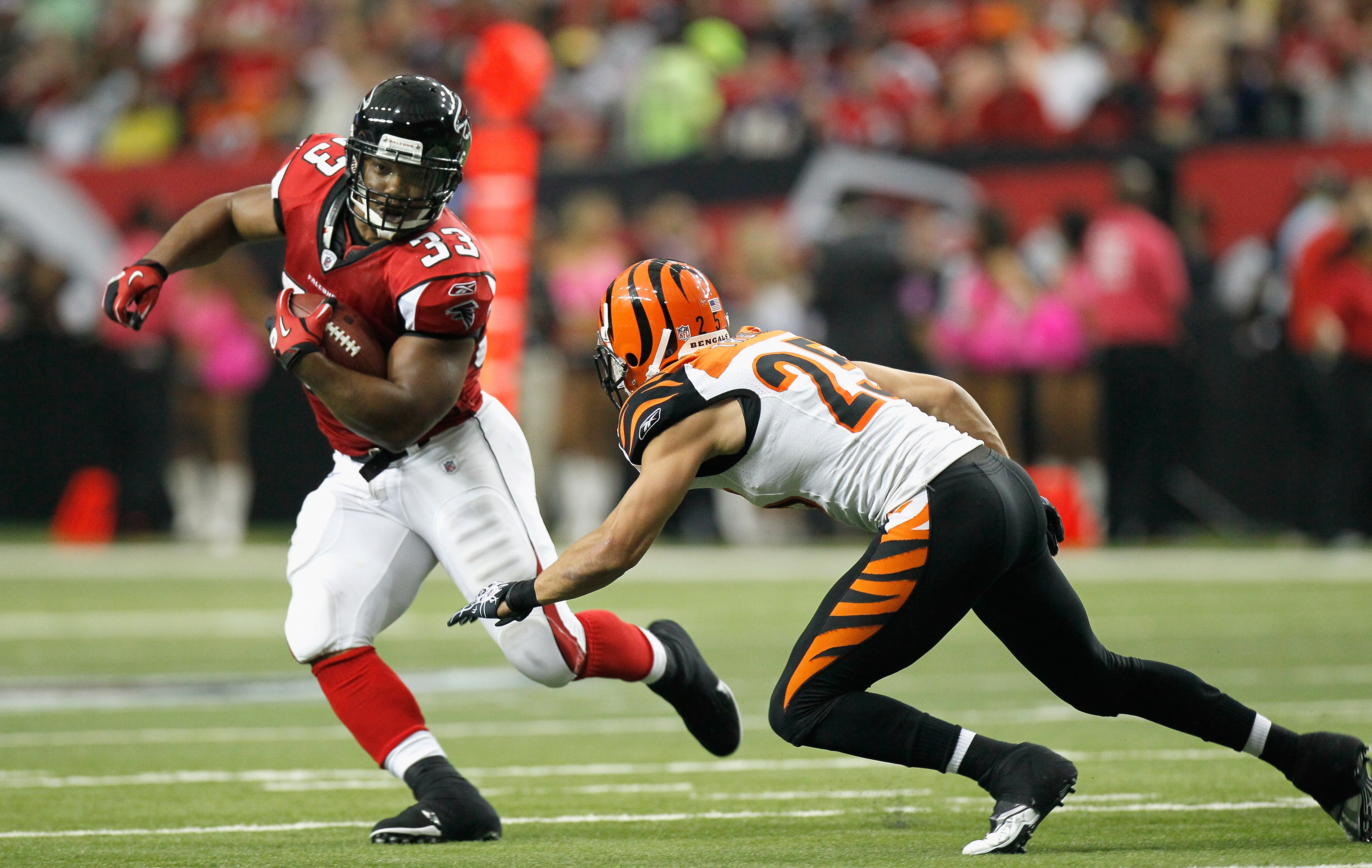 ATLANTA - OCTOBER 24:  Michael Turner #33 of the Atlanta Falcons rushes away from Morgan Trent #25 of the Cincinnati Bengals at Georgia Dome on October 24, 2010 in Atlanta, Georgia.  (Photo by Kevin C. Cox/Getty Images)