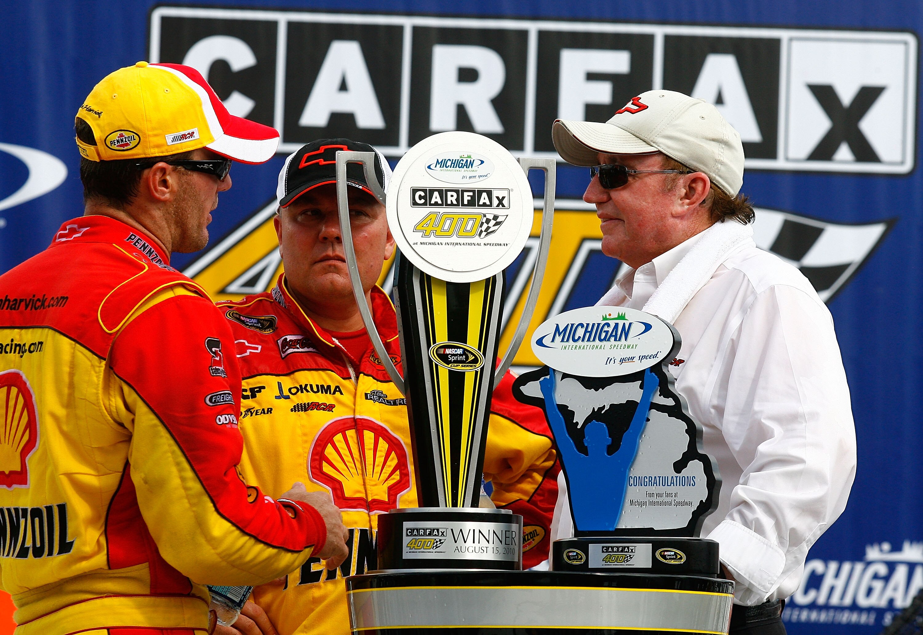BROOKLYN, MI - AUGUST 15:  Kevin Harvick (L), driver of the #29 Shell / Pennzoil Chevrolet, crew chief Gil Martin (c) and team owner Richard Childress (R) celebrate with the trophy in victory lane after winning the NASCAR Sprint Cup Series CARFAX 400 at M