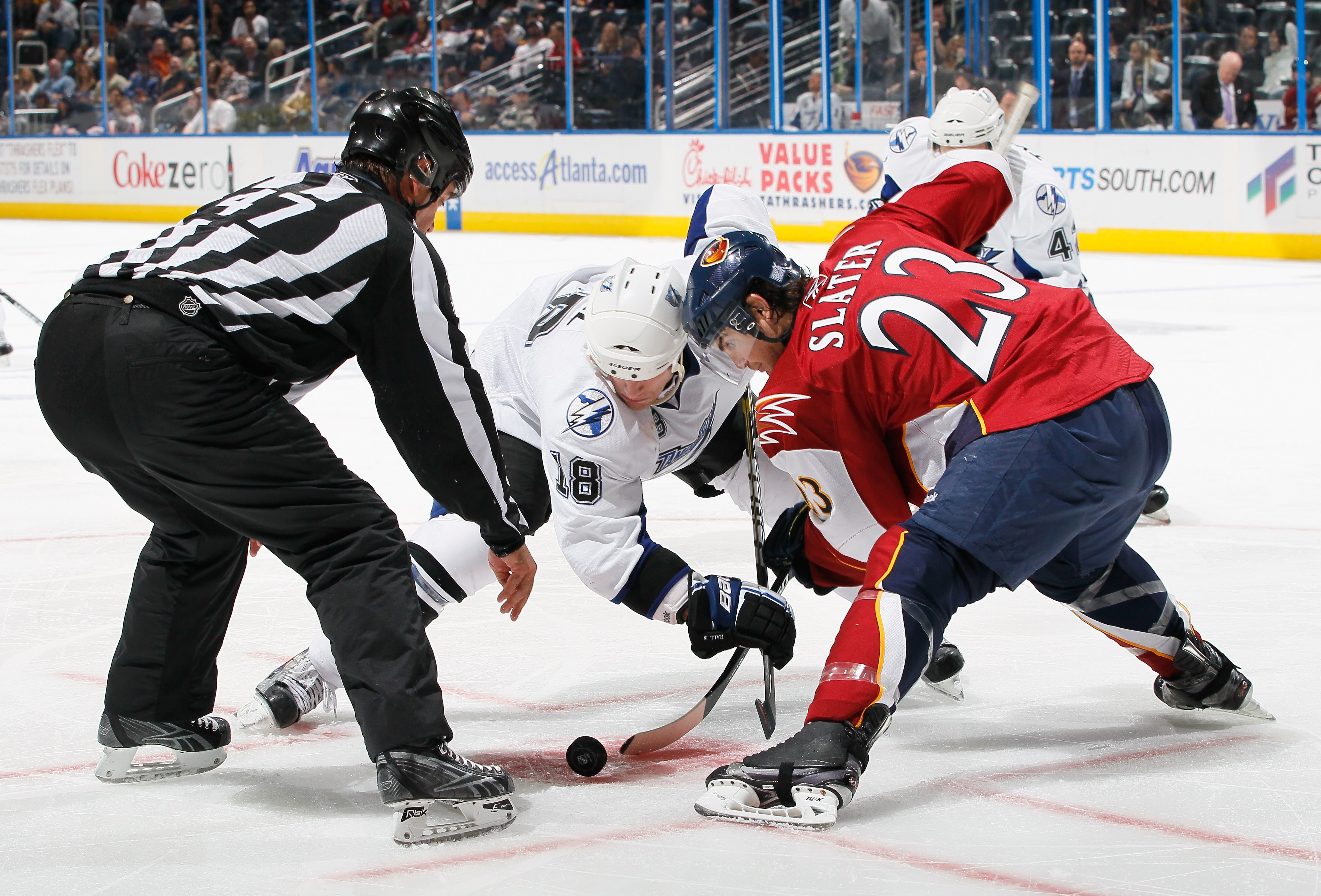 ATLANTA - OCTOBER 22:  Linesman Dan Schachte #47 drops the puck between Adam Hall #18 of the Tampa Bay Lightning and Jim Slater #23 of the Atlanta Thrashers at Philips Arena on October 22, 2010 in Atlanta, Georgia.  (Photo by Kevin C. Cox/Getty Images)