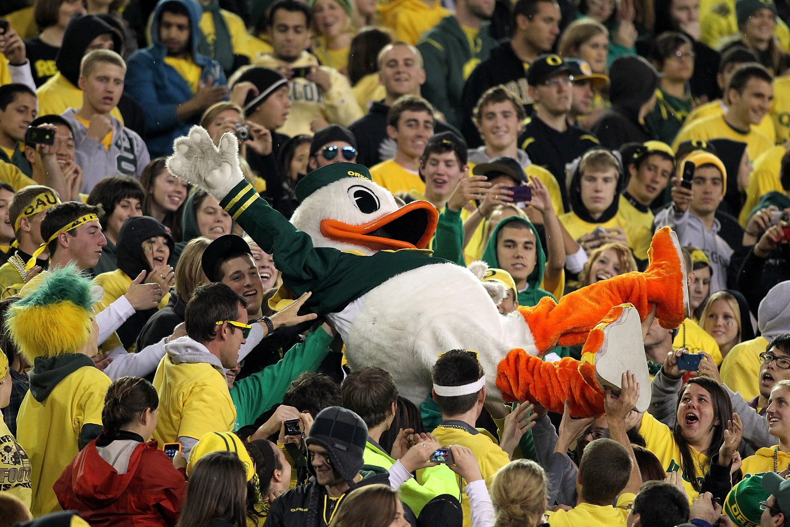 EUGENE, OR - OCTOBER 21:  The Oregon Duck mascot is lifted into the crowd during the game against the UCLA Bruins  on October 21, 2010 at the Autzen Stadium in Eugene, Oregon.  (Photo by Jonathan Ferrey/Getty Images)