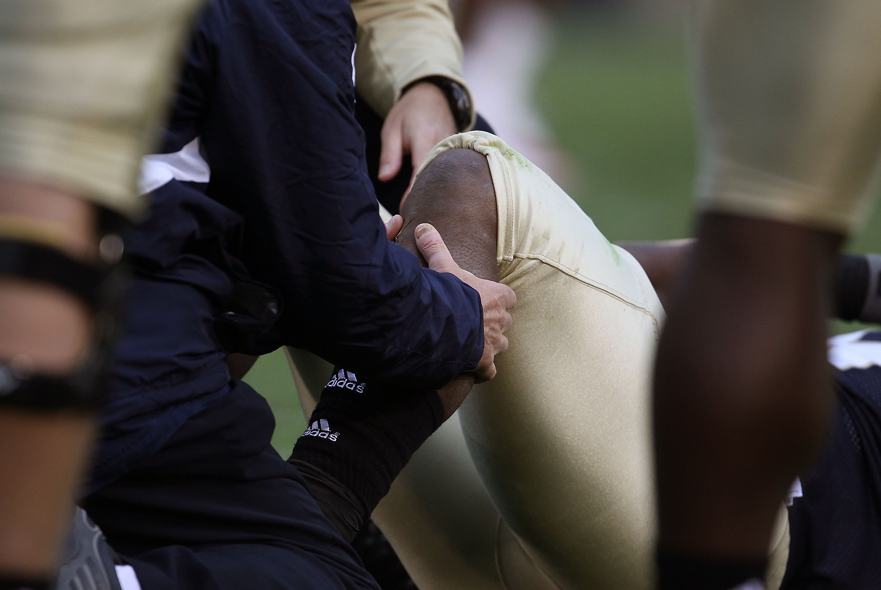 SOUTH BEND, IN - SEPTEMBER 25: A trainer checks the knee of Armando Allen Jr. #5 of the Notre Dame Fighting Irish after an ijury against the Stanford Cardinal at Notre Dame Stadium on September 25, 2010 in South Bend, Indiana. Stanford defeated Notre Dame
