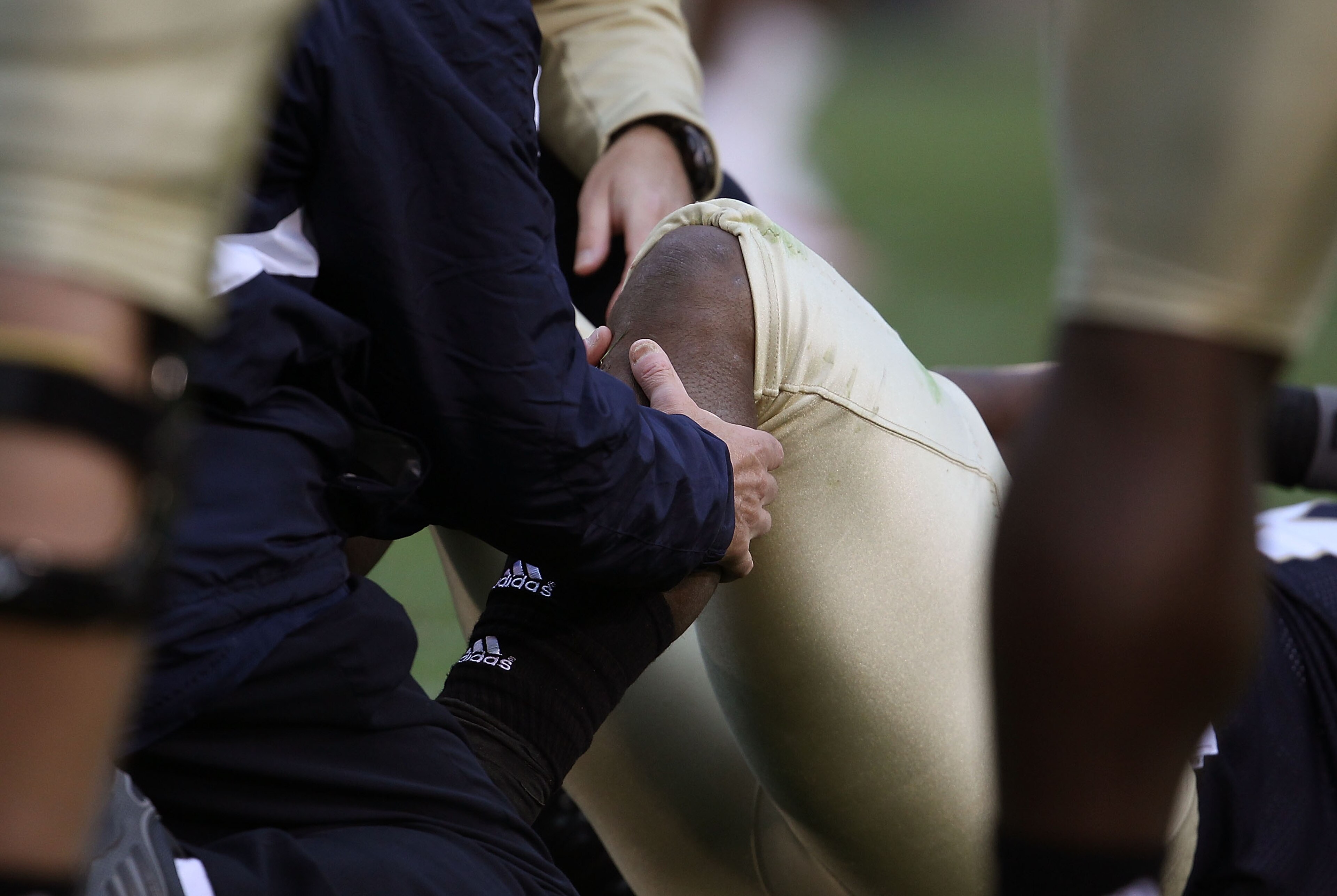 SOUTH BEND, IN - SEPTEMBER 25: A trainer checks the knee of Armando Allen Jr. #5 of the Notre Dame Fighting Irish after an ijury against the Stanford Cardinal at Notre Dame Stadium on September 25, 2010 in South Bend, Indiana. Stanford defeated Notre Dame