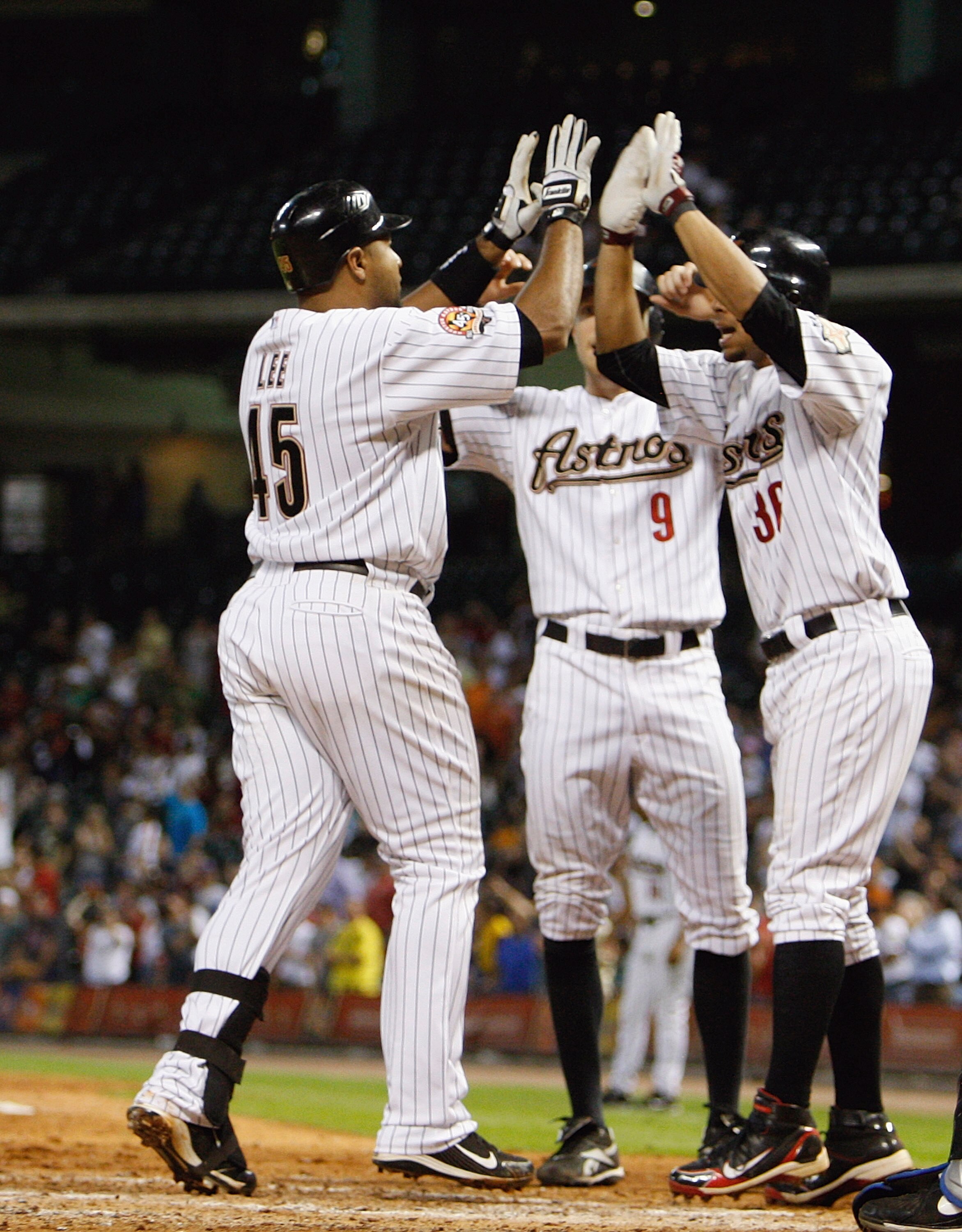 HOUSTON - AUGUST 19:  Carlos Lee #45 of the Houston Astros is congratulated by Angel Sanchez #36 and Hunter Pence #9 after hitting a three run home run in the seventh inning against the New York Mets at Minute Maid Park on August 19, 2010 in Houston, Texa