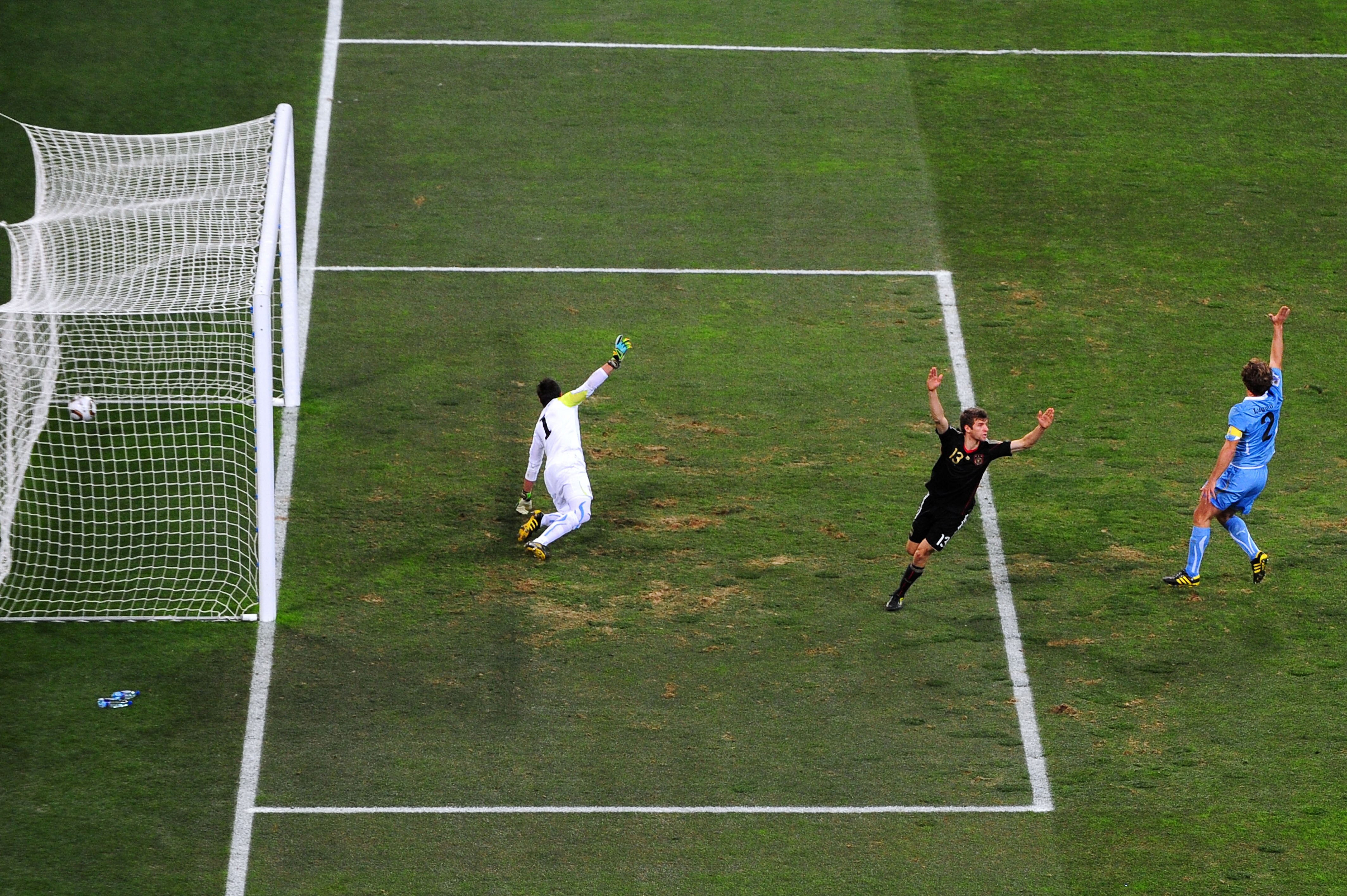 PORT ELIZABETH, SOUTH AFRICA - JULY 10:  Thomas Mueller of Germany celebrates scoring the opening goal past Fernando Muslera of Uruguay during the 2010 FIFA World Cup South Africa Third Place Play-off match between Uruguay and Germany at The Nelson Mandel