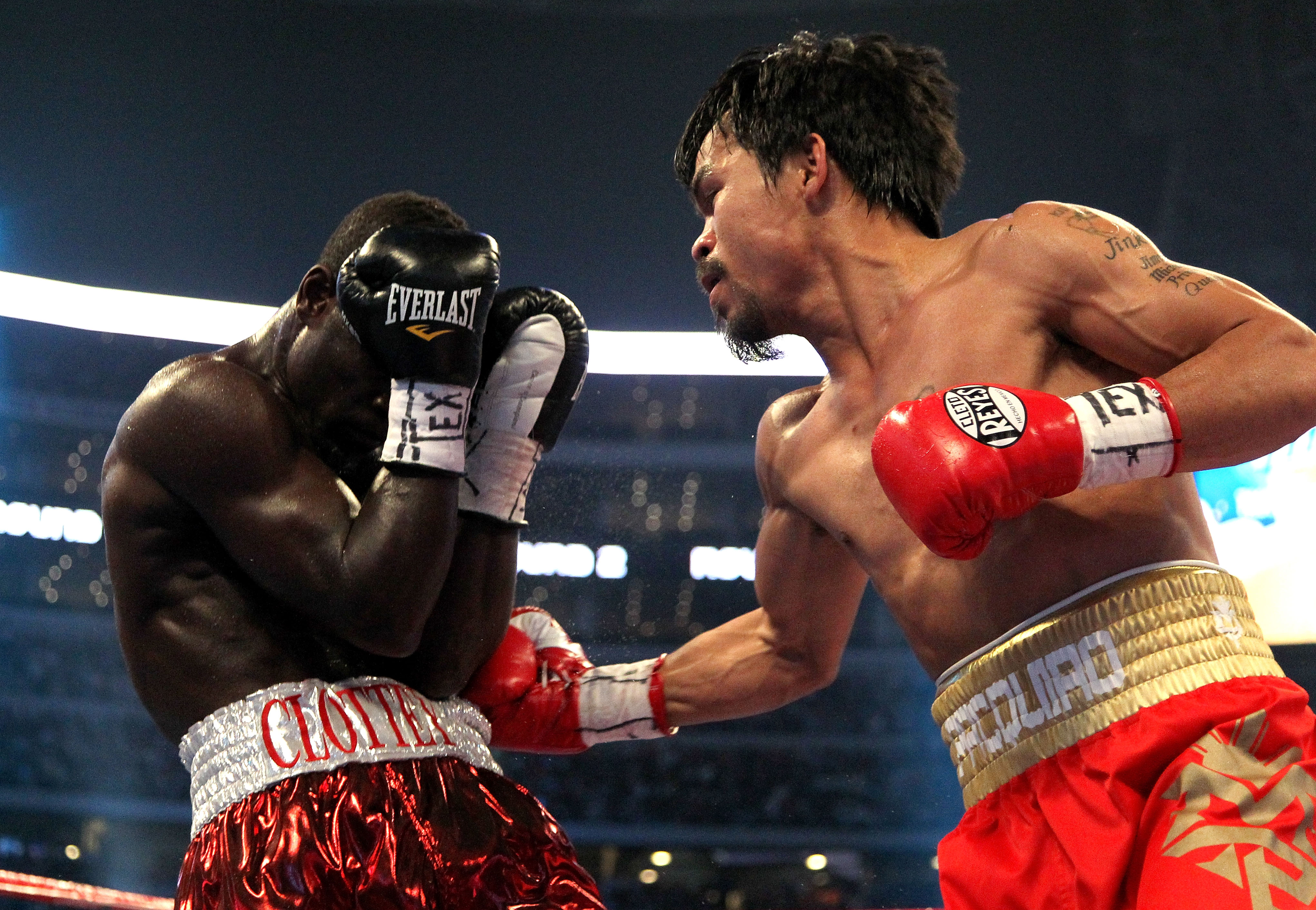 ARLINGTON, TX - MARCH 13:  (R-L) Manny Pacquiao of the Philippines throws a right to the body of Joshua Clottey of Ghana during the WBO welterweight title fight at Cowboys Stadium on March 13, 2010 in Arlington, Texas.  (Photo by Jed Jacobsohn/Getty Image