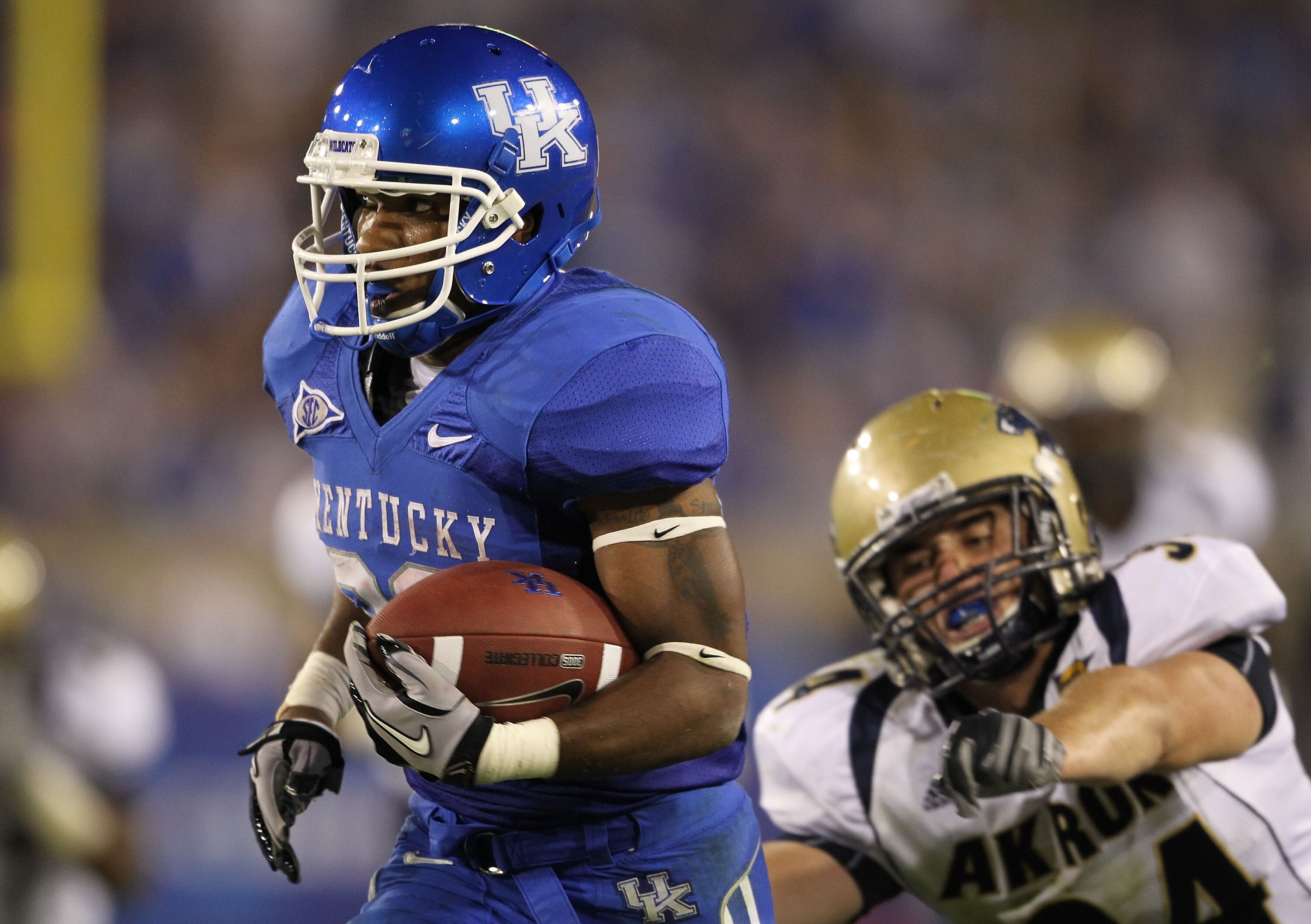 LEXINGTON, KY - SEPTEMBER 18:  Derrick Locke #20 of the Kentucky Wildcats runs for a touchdown while defended by Brian Wagner #34 of the Akron Zips during the game  at Commonwealth Stadium on September 18, 2010 in Lexington, Kentucky.  (Photo by Andy Lyon