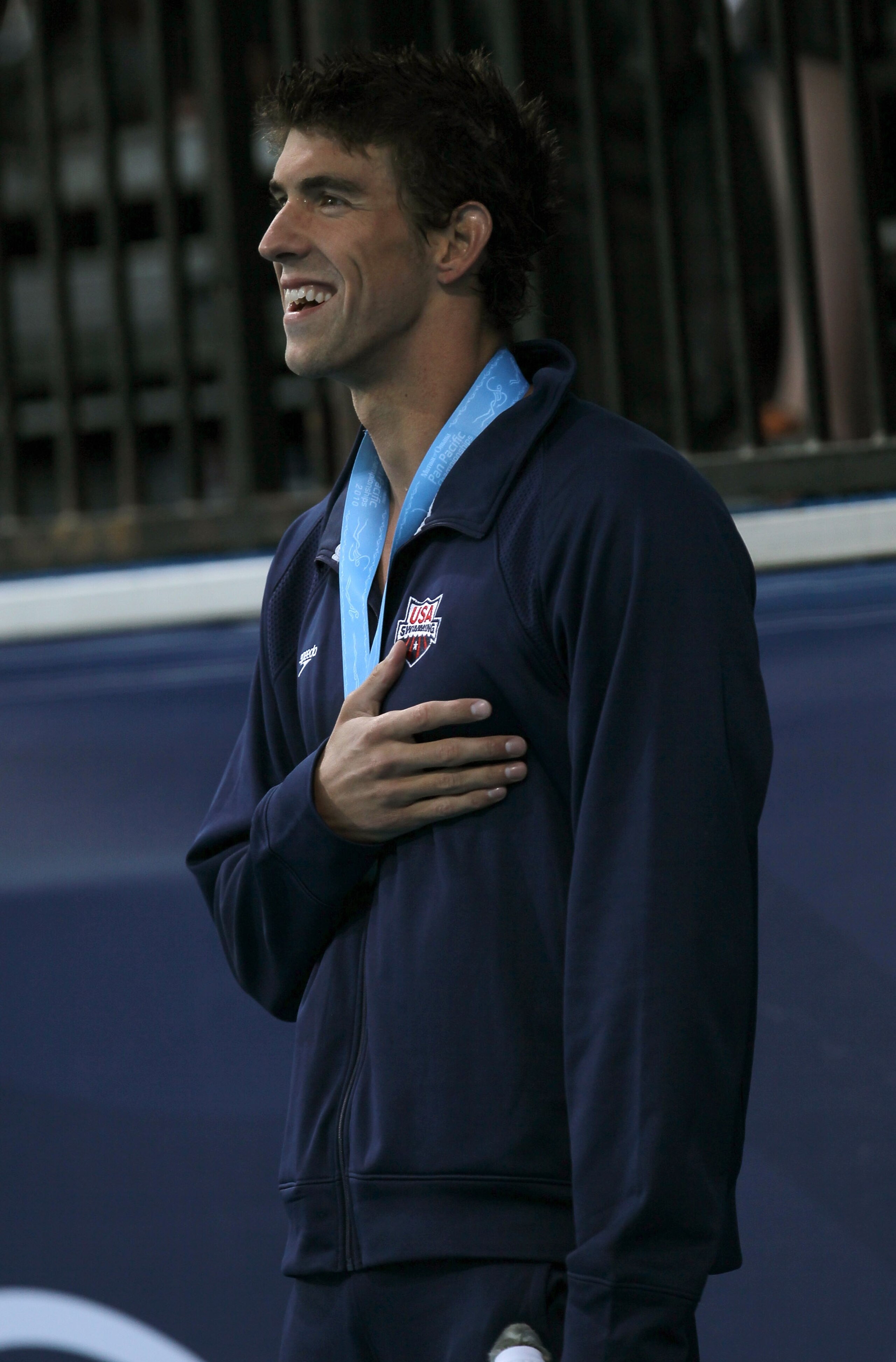 IRVINE, CA - AUGUST 20:  Michael Phelps stands during the national anthem during awards ceremonies after winning the men's 100m butterfly during the Mutual of Omaha Pan Pacific Championships at the William Woollett Jr. Aquatic Center on August 20, 2010 in