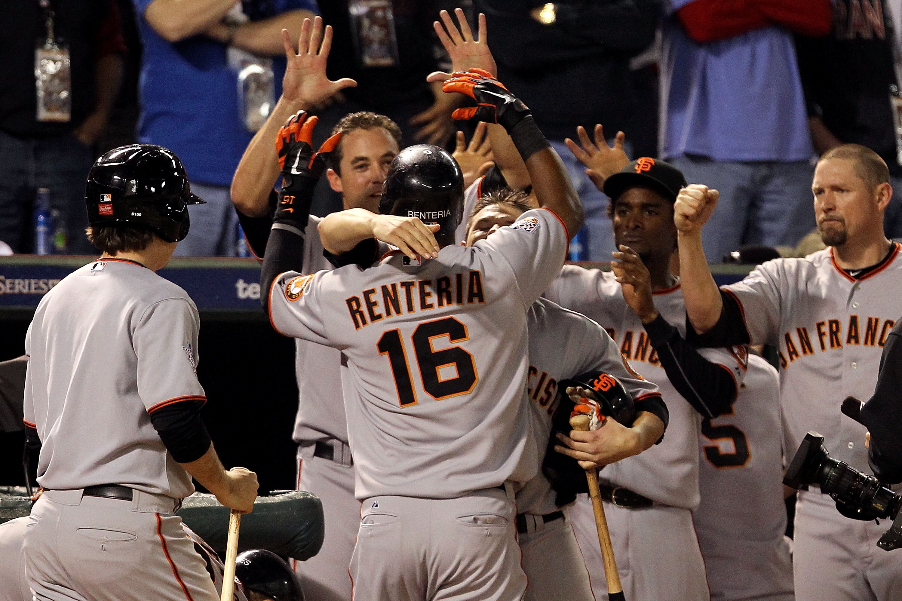 ARLINGTON, TX - NOVEMBER 01:  Edgar Renteria (R) #16 of the San Francisco Giants is congratulated by teammates as he returns to the dugout after Renteria hit a 3-run home run in the seventh inning against Cliff Lee #33 of the Texas Rangers in Game Five of