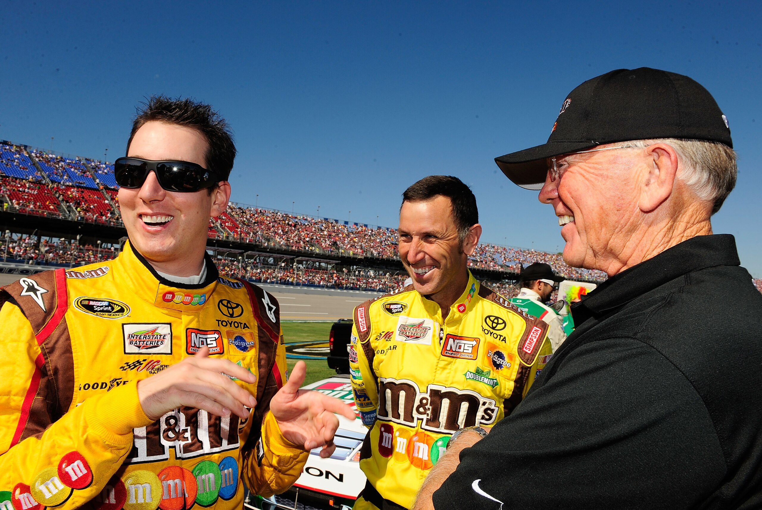 TALLADEGA, AL - OCTOBER 31:  Kyle Busch (L), driver of the #18 M&M's Toyota, talks to team owner Joe Gibbs (R) and a crew member prior to the start of the NASCAR Sprint Cup Series AMP Energy Juice 500 at Talladega Superspeedway on October 31, 2010 in Tall