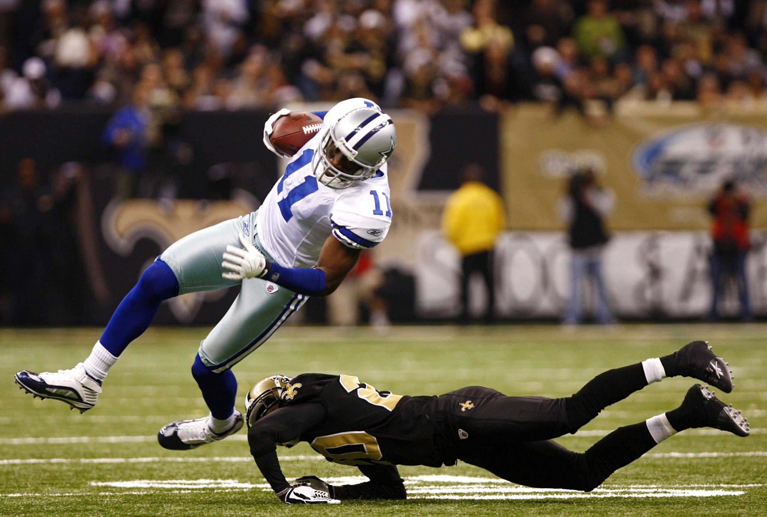 NEW ORLEANS - DECEMBER 19:  Wide receiver Roy E. Williams #11 of the Dallas Cowboys is hit by cornerback Randall Gay #20 of the New Orleans Saints at the Louisiana Superdome on December 19, 2009 in New Orleans, Louisiana. (Photo by Scott Halleran/Getty Im