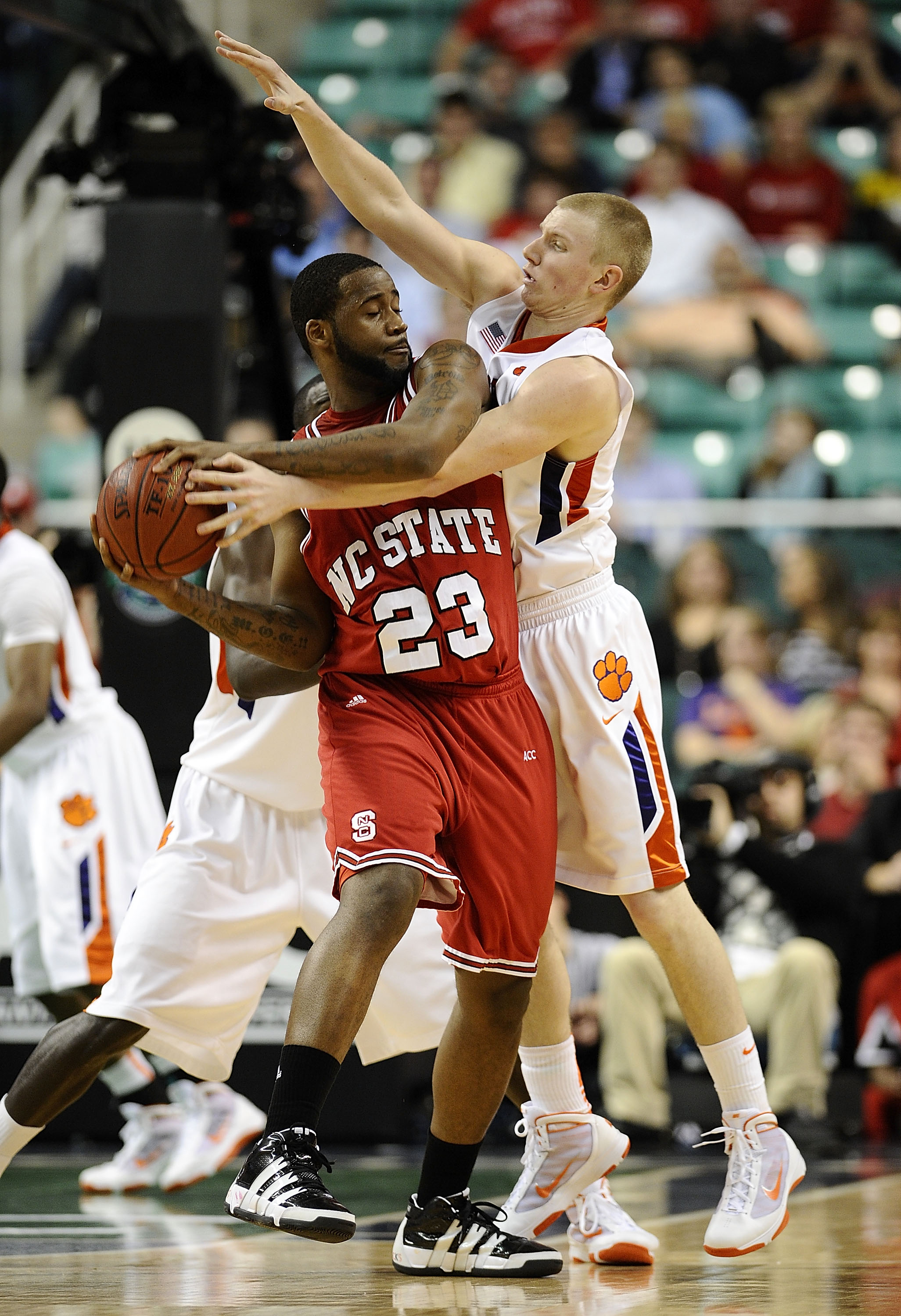 GREENSBORO, NC - MARCH 11:  Tanner Smith #5 of the Clemson Tigers guards Tracy Smith #23 of the North Carolina State Wolfpack in their first-round game in the 2010 ACC Men's Basketball Tournament at the Greensboro Coliseum on March 11, 2010 in Greensboro,