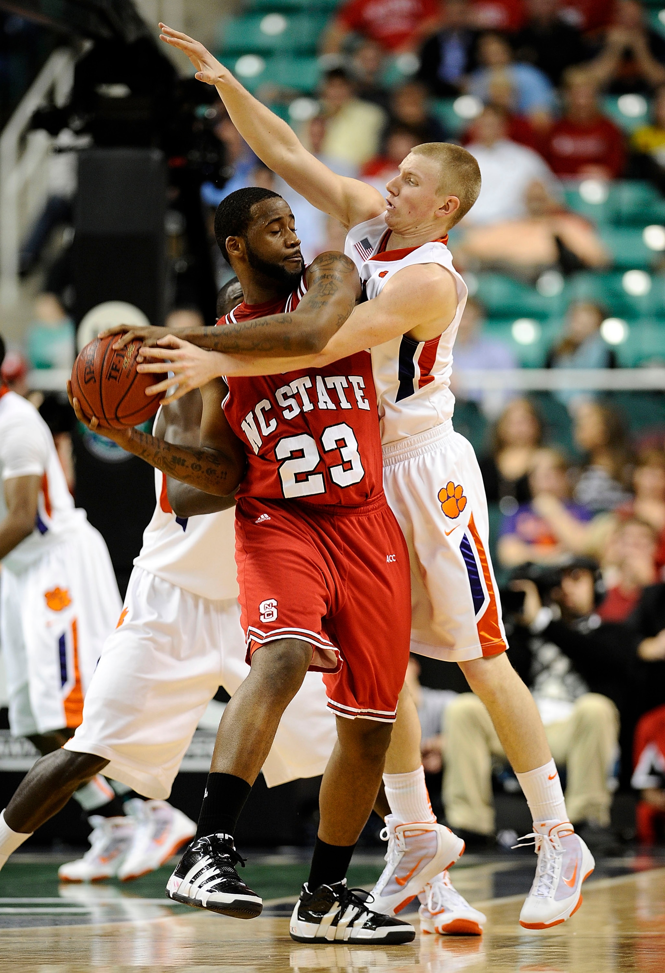 GREENSBORO, NC - MARCH 11:  Tanner Smith #5 of the Clemson Tigers guards Tracy Smith #23 of the North Carolina State Wolfpack in their first-round game in the 2010 ACC Men's Basketball Tournament at the Greensboro Coliseum on March 11, 2010 in Greensboro,
