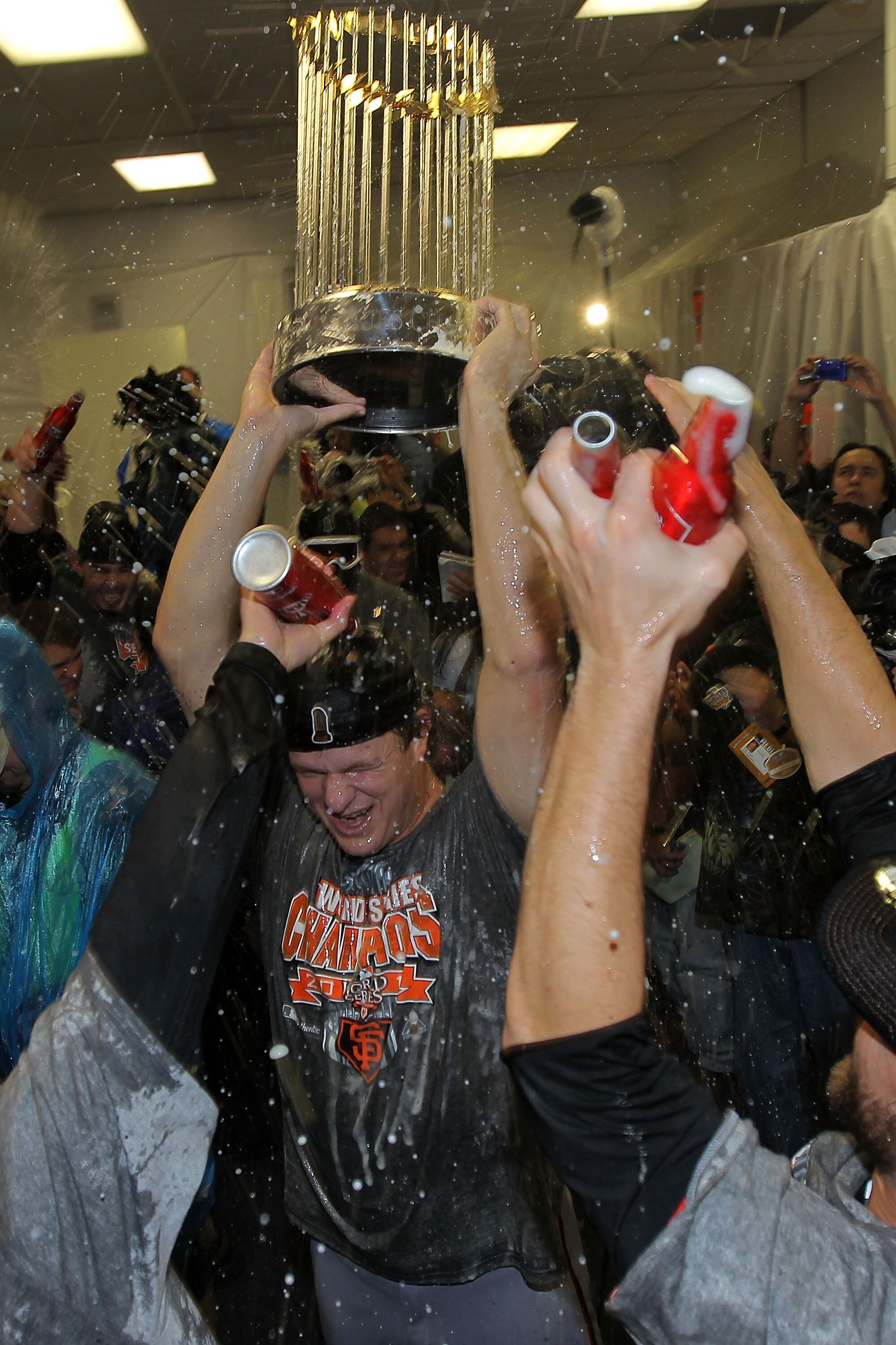 ARLINGTON, TX - NOVEMBER 01:  Matt Cain of the San Francisco Giants holds up the World Series trophy as he celebrates with his teammates in the locker room after the Giants won 3-1 against the Texas Rangers in Game Five of the 2010 MLB World Series at Ran