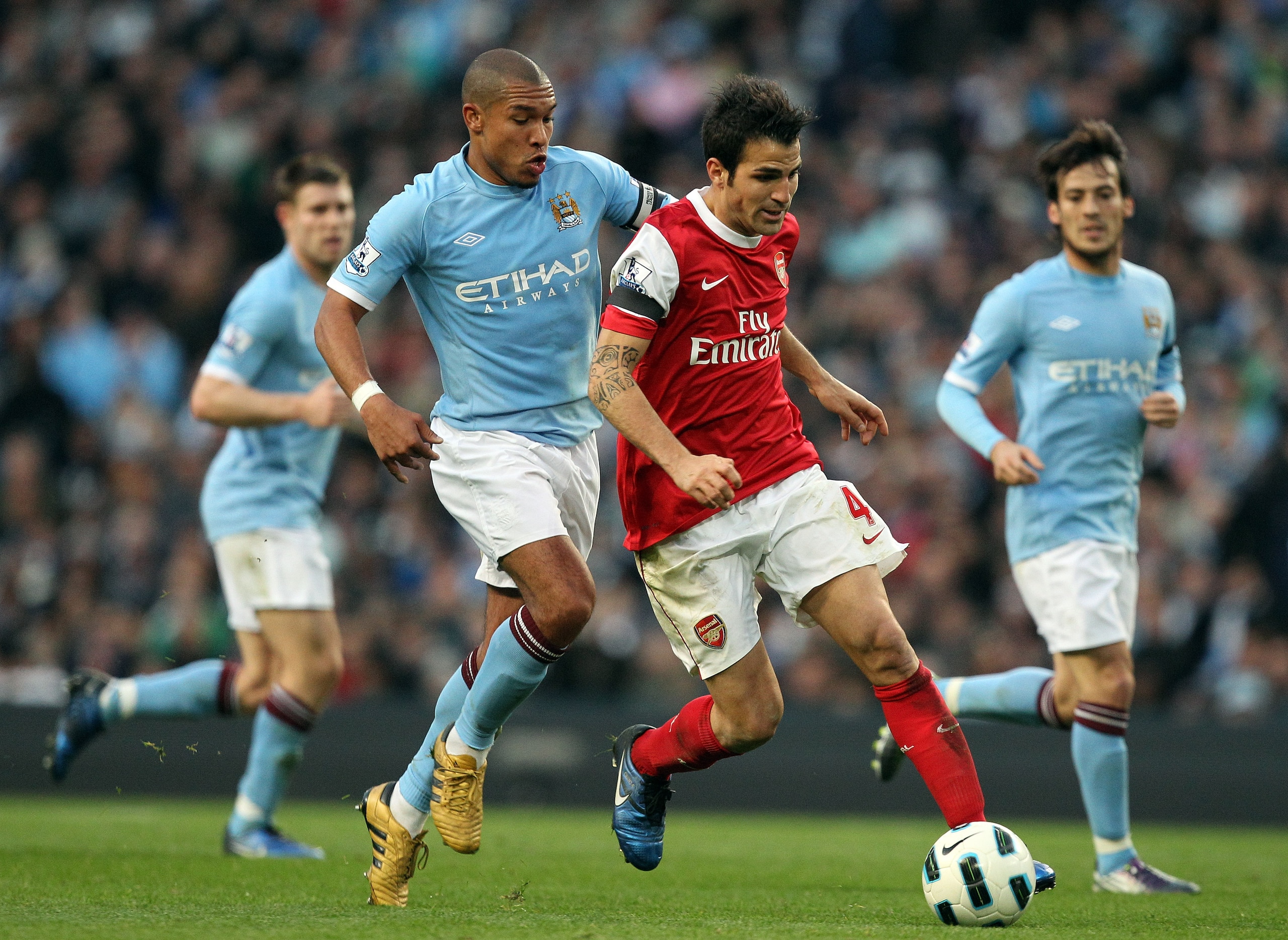MANCHESTER, ENGLAND - OCTOBER 24:  Cesc Fabregas of Arsenal holds off Nigel De Jong of City during the Barclays Premier League match between Manchester City and Arsenal at City of Manchester Stadium on October 24, 2010 in Manchester, England.  (Photo by R
