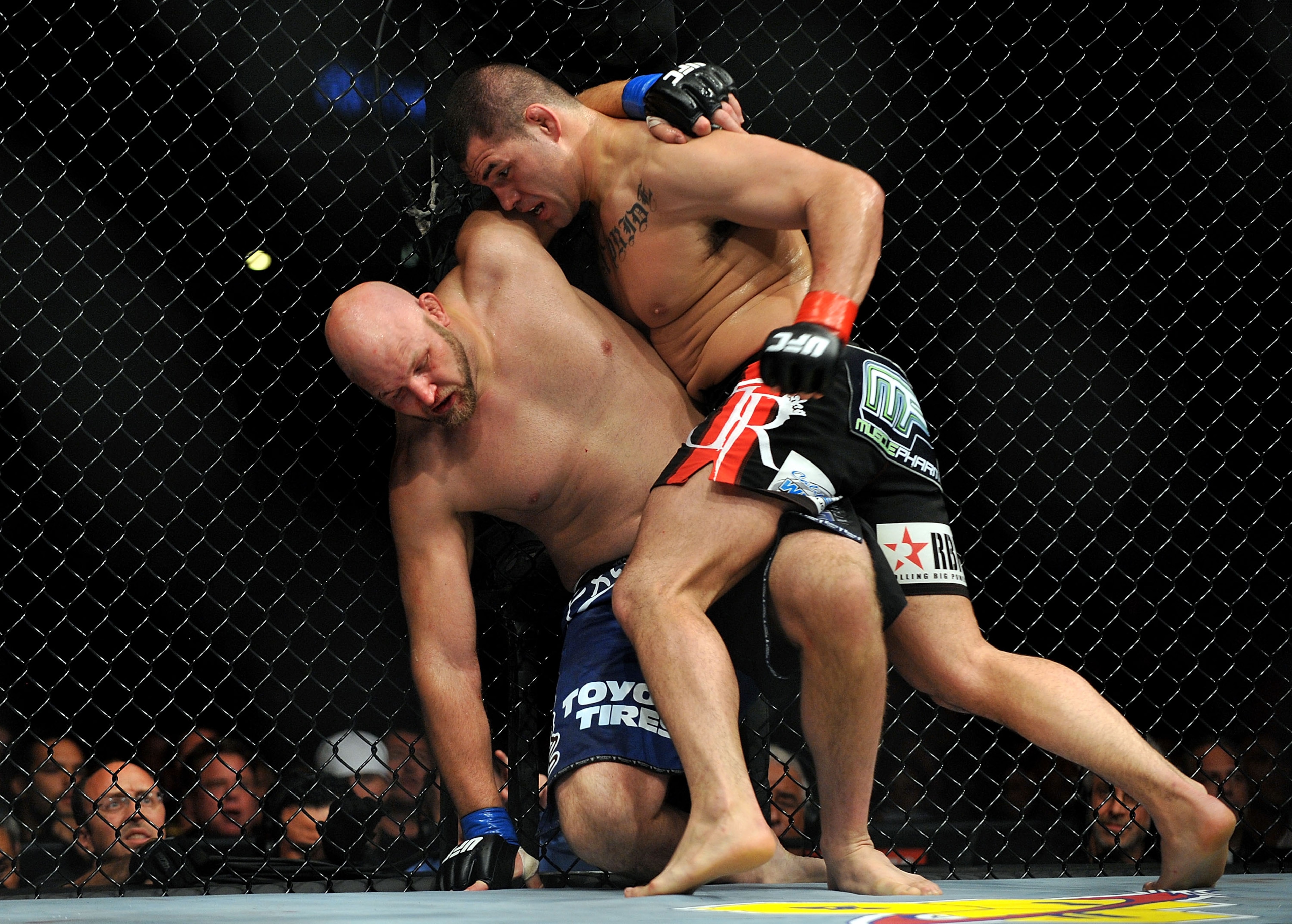 LOS ANGELES, CA - OCTOBER 24:  UFC fighter Cain Velasquez (R) hits UFC fighter Ben Rothwell (L) up against the fence during their Heavyweight bout at UFC 104: Machida vs. Shogun at Staples Center on October 24, 2009 in Los Angeles, California.  Velasquez