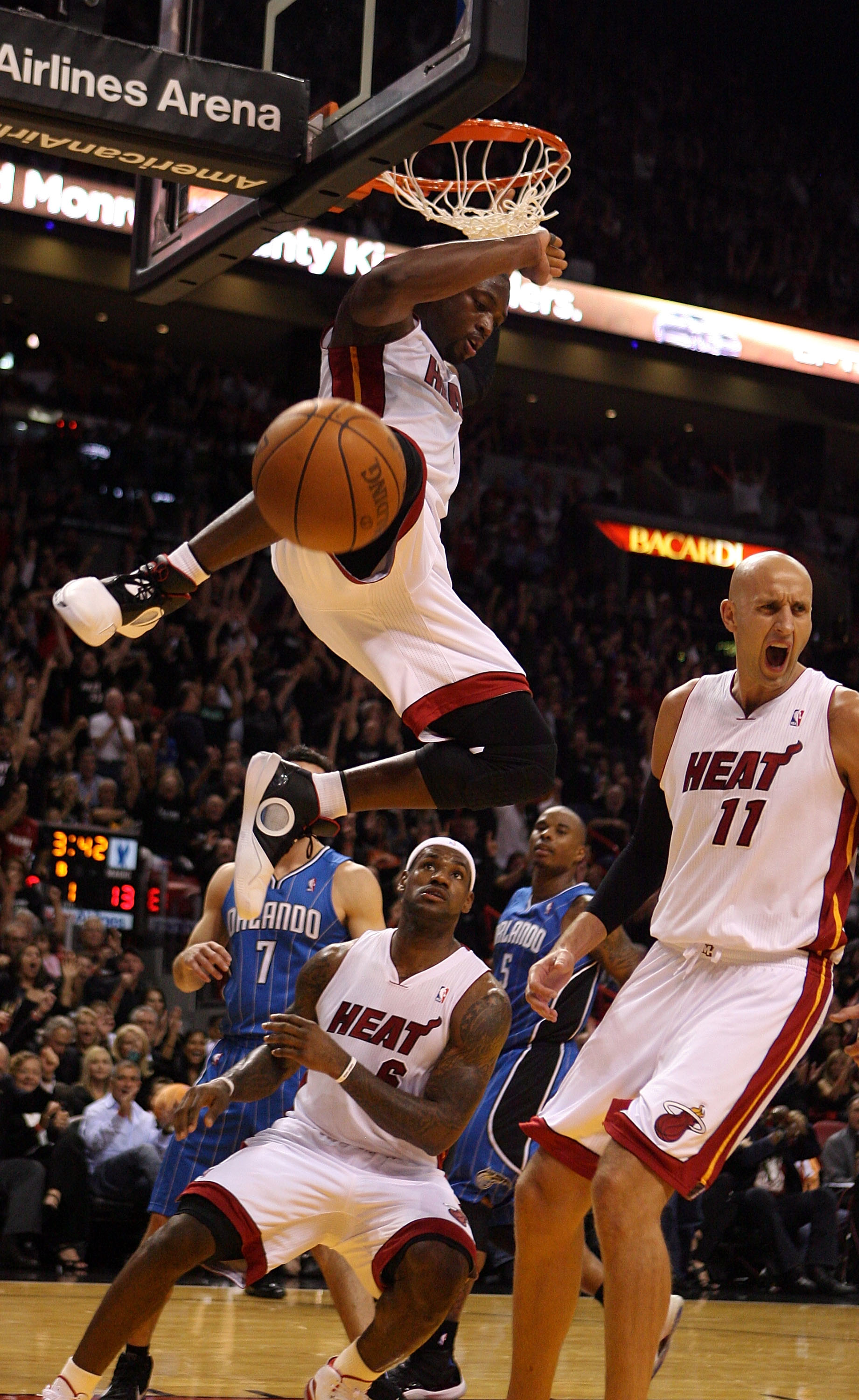 MIAMI - OCTOBER 29:  Guard Dwyane Wade #3 of  the Miami Heat dunks against guard J.J. Redick #7  of the Orlando Magic as teammates LeBron James #6 and Zydrunas Ilgauskas #11 look on at American Airlines Arena on October 29, 2010 in Miami, Florida.  (Photo