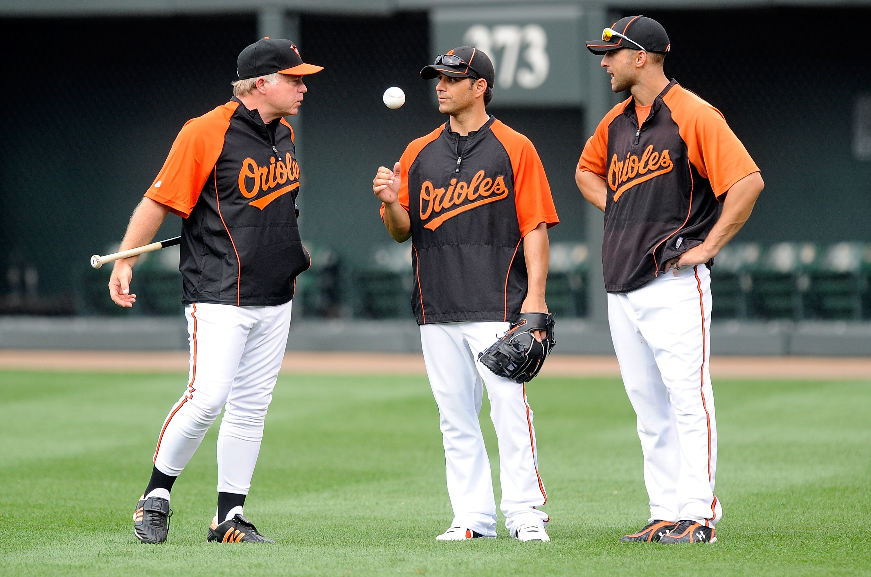 BALTIMORE - AUGUST 03:  Manager Buck Showalter of the Baltimore Orioles talks with Brian Roberts #1 and Nick Markakis #21 before the game against the Los Angeles Angels of Anaheim at Camden Yards on August 3, 2010 in Baltimore, Maryland.  (Photo by Greg F