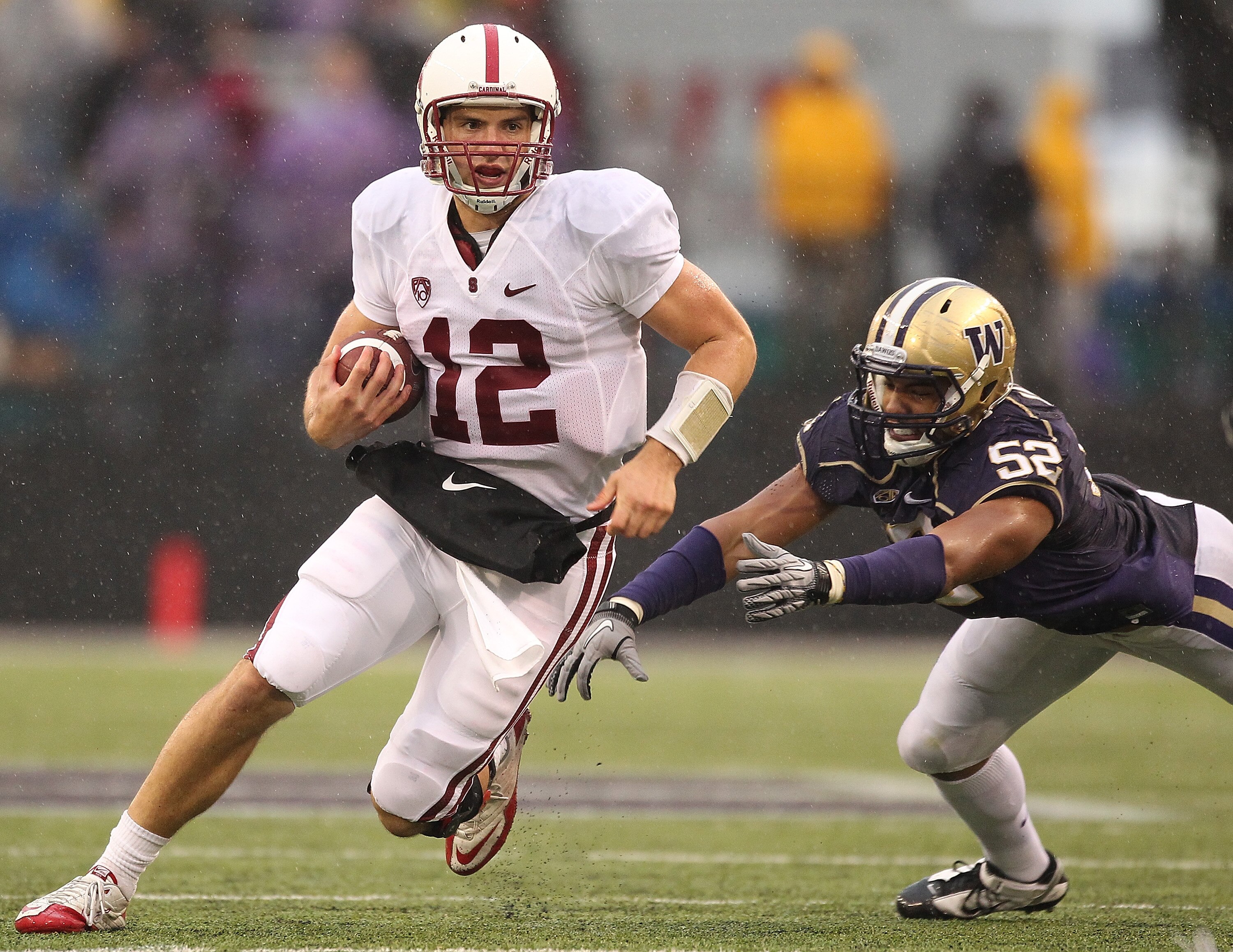 SEATTLE - OCTOBER 30:  Quarterback Andrew Luck #12 of the Stanford Cardinal rushes against Hau'oli Jamora #52 of the Washington Huskies on October 30, 2010 at Husky Stadium in Seattle, Washington. (Photo by Otto Greule Jr/Getty Images)