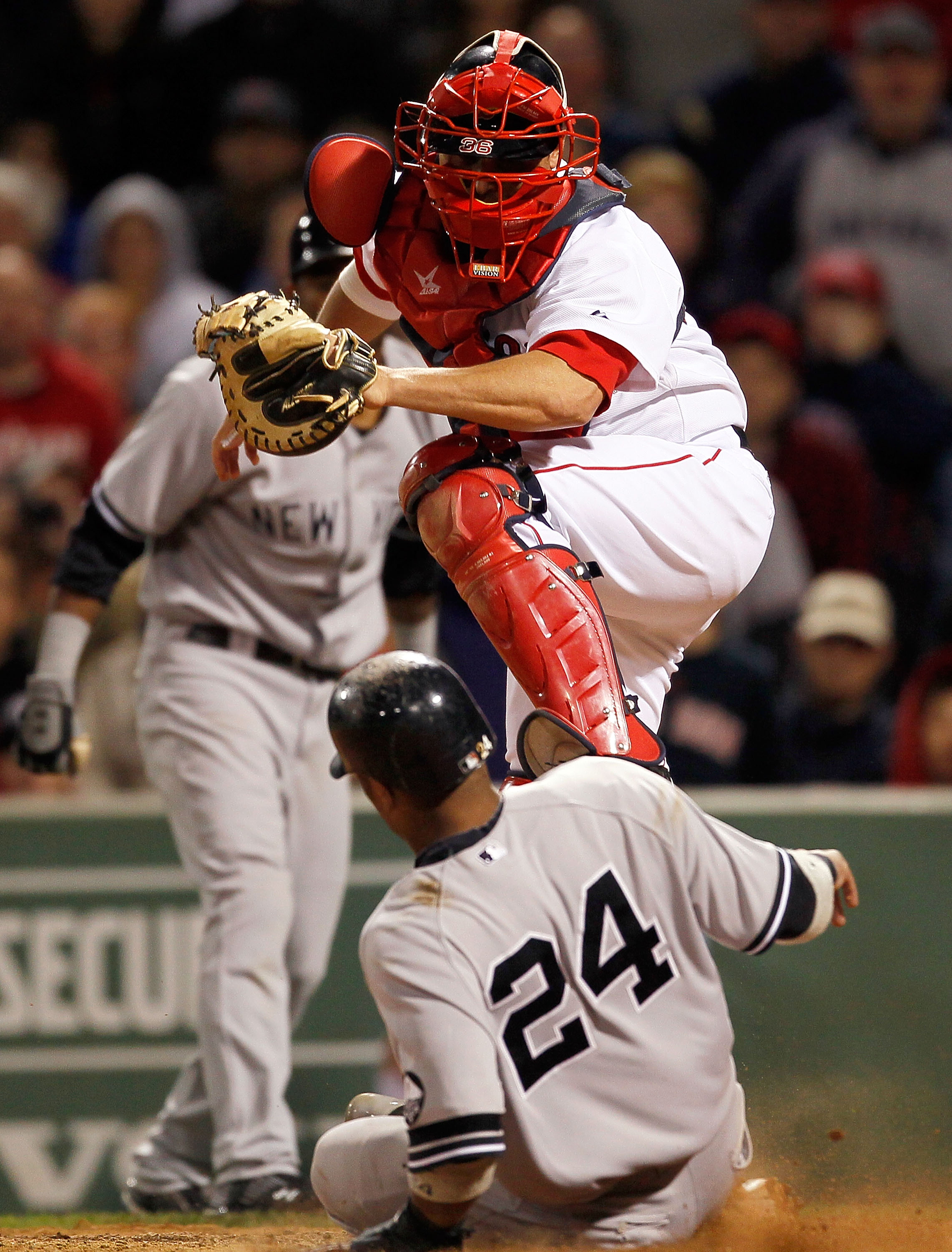 BOSTON - OCTOBER 2:  Robinson Cano #24 of the New York Yankees scores despite the defense of catcher Kevin Cash #36 of the Boston during the second game of a doubleheader at Fenway Park, October 2, 2010, in Boston, Massachusetts. (Photo by Jim Rogash/Gett