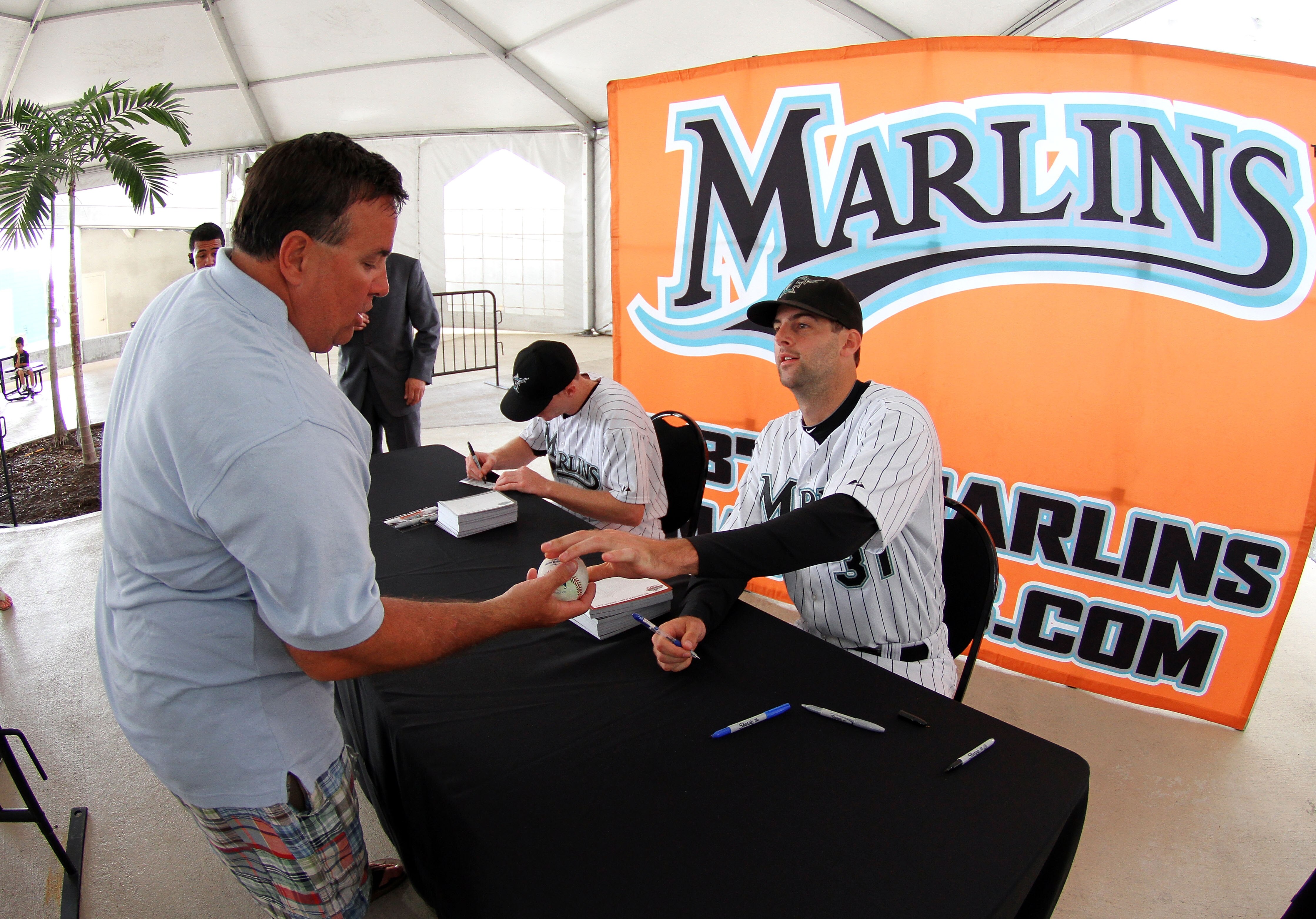 MIAMI - APRIL 09:  Burke Badenhop #31 of the Florida Marlins signs a ball for a fan before taking on the Los Angeles Dodgers during the Marlins home opening game at Sun Life Stadium on April 9, 2010 in Miami, Florida.  (Photo by Doug Benc/Getty Images)