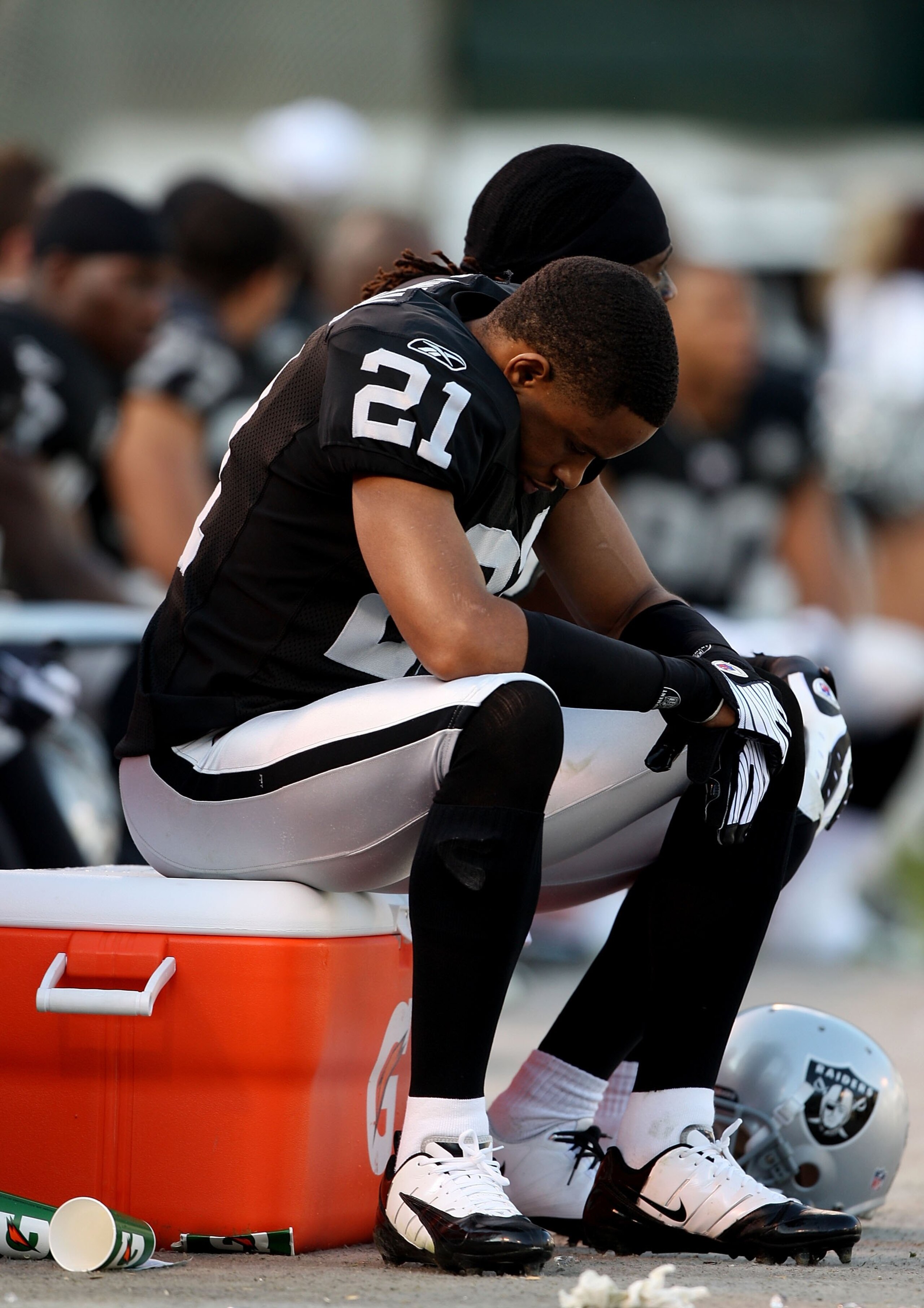 OAKLAND, CA - JANUARY 03:  Nnamdi Asomugha #21 of the Oakland Raiders sits on the bench against the Baltimore Ravens during an NFL game at Oakland-Alameda County Coliseum on January 3, 2010 in Oakland, California.  (Photo by Jed Jacobsohn/Getty Images)