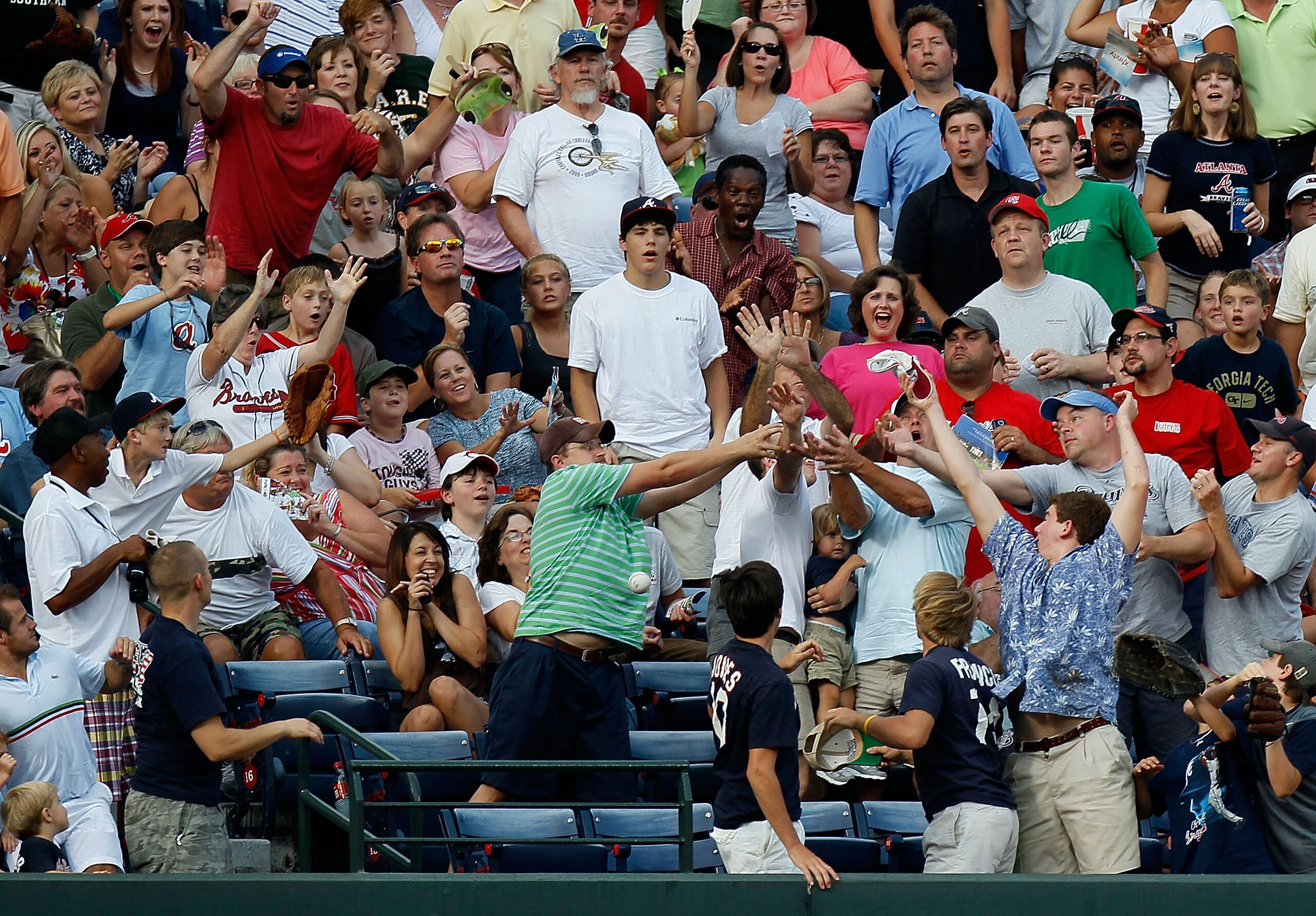 ATLANTA - JULY 15:  Fans attempt to catch a solo homer hit by Martin Prado #14 (not pictured) of the Atlanta Braves during the third inning against the Milwaukee Brewers at Turner Field on July 15, 2010 in Atlanta, Georgia.  (Photo by Kevin C. Cox/Getty I