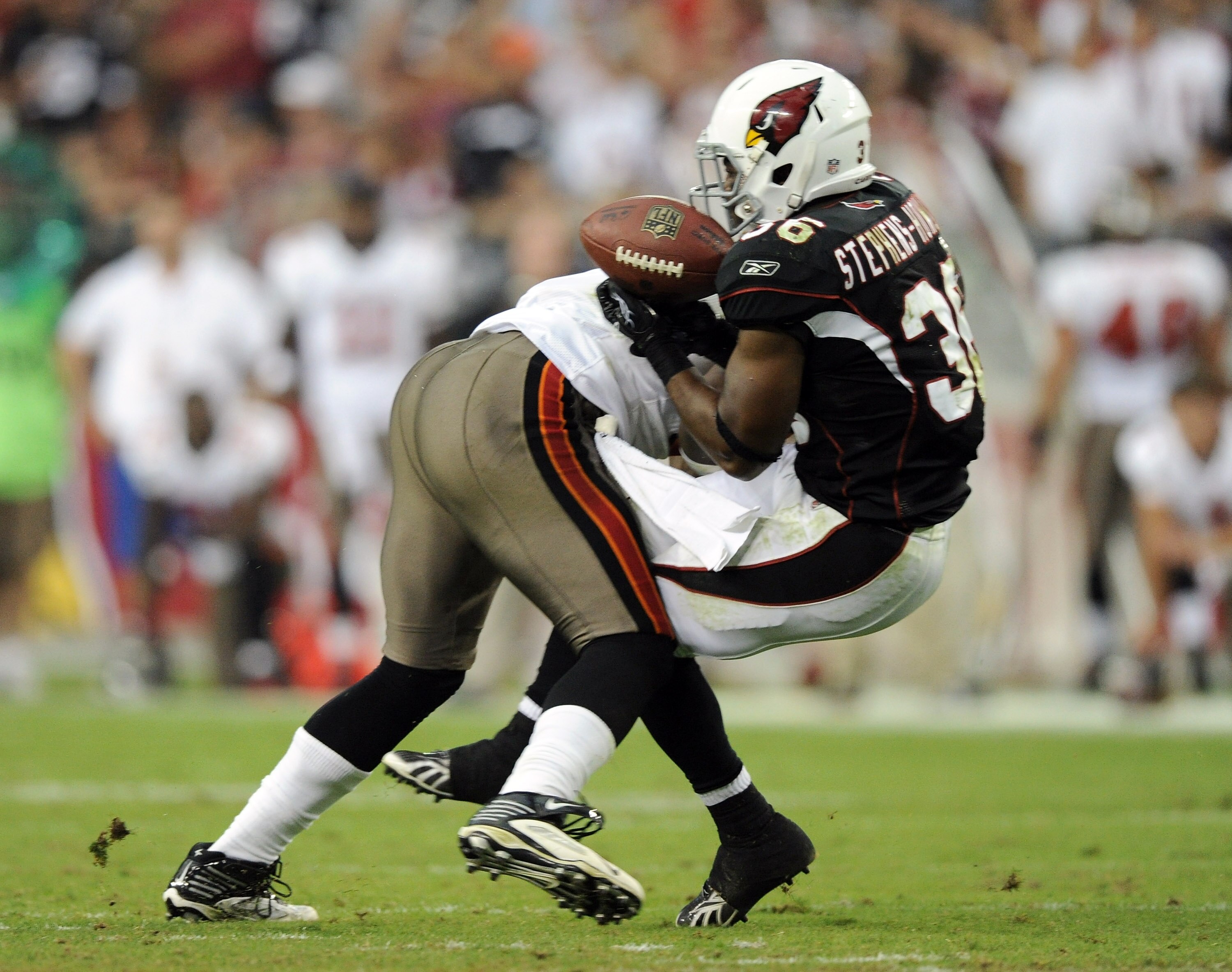 GLENDALE, AZ - OCTOBER 31:  LaRod Stephens-Howling #36 of the Arizona Cardinals takes a hit from Geno Hayes #54 of the Tampa Bay Buccaneers resulting in an interception and injury during the fourth quarter at University of Phoenix Stadium on October 31, 2