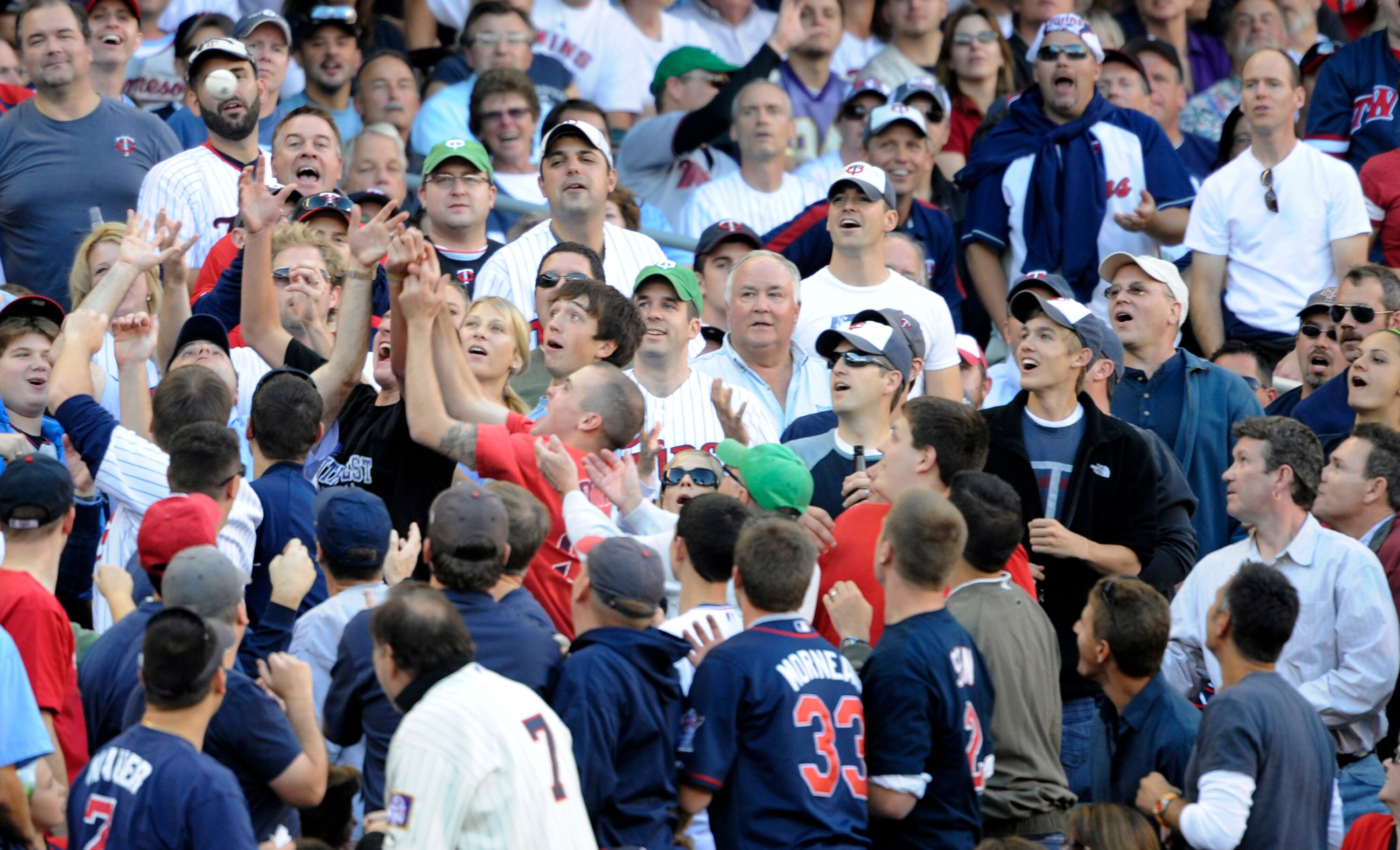 MINNEAPOLIS, MN - OCTOBER 7: Fans reach for a foul ball during game two of the ALDS game between the New York Yankees and the Minnesota Twins on October 7, 2010 at Target Field in Minneapolis, Minnesota.  (Photo by Hannah Foslien/Getty Images)