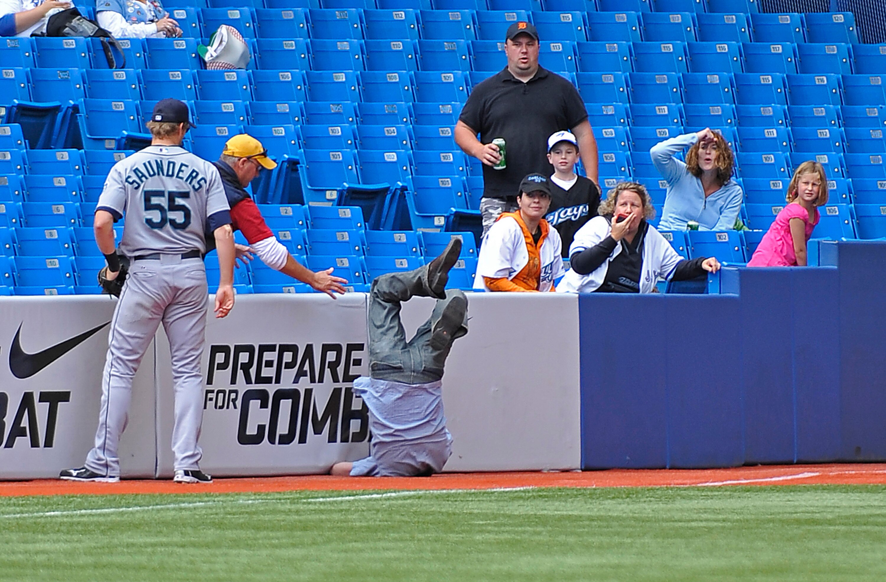 TORONTO - SEPTEMBER 23:   Michael Saunders #55 of the Seattle Mariners watches as a fan tumbles onto the field trying to catch a foul ball during game action against the Toronto Blue Jays September 23, 2010 at Rogers Centre in Toronto, Ontario, Canada. (P