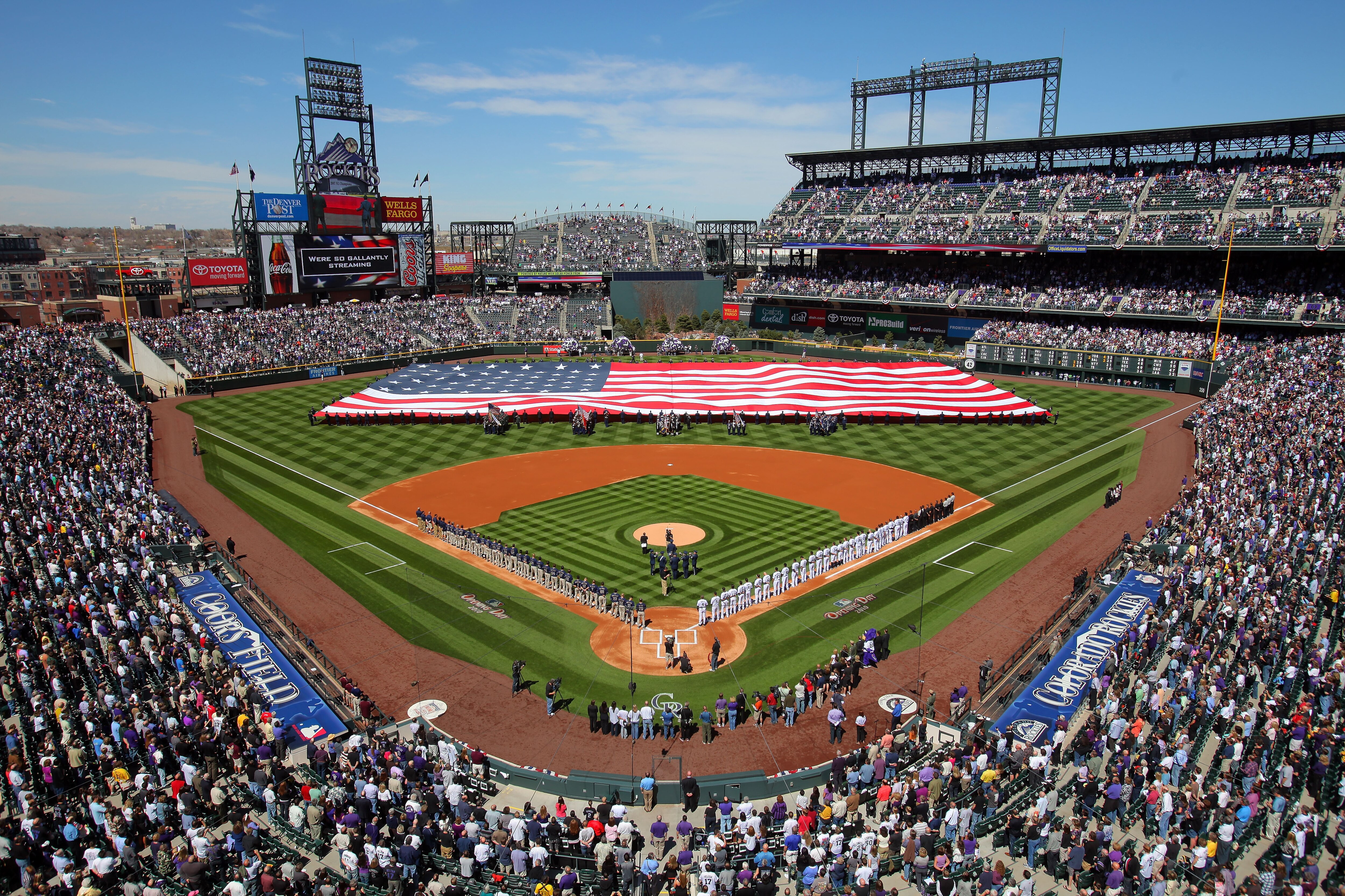 DENVER - APRIL 09:  Players and fans observe the national anthem as the stars and stripes is presented by members of the US military as the Colorado Rockies host the San Diego Padres during MLB action on Opening Day at Coors Field on April 9, 2010 in Denv