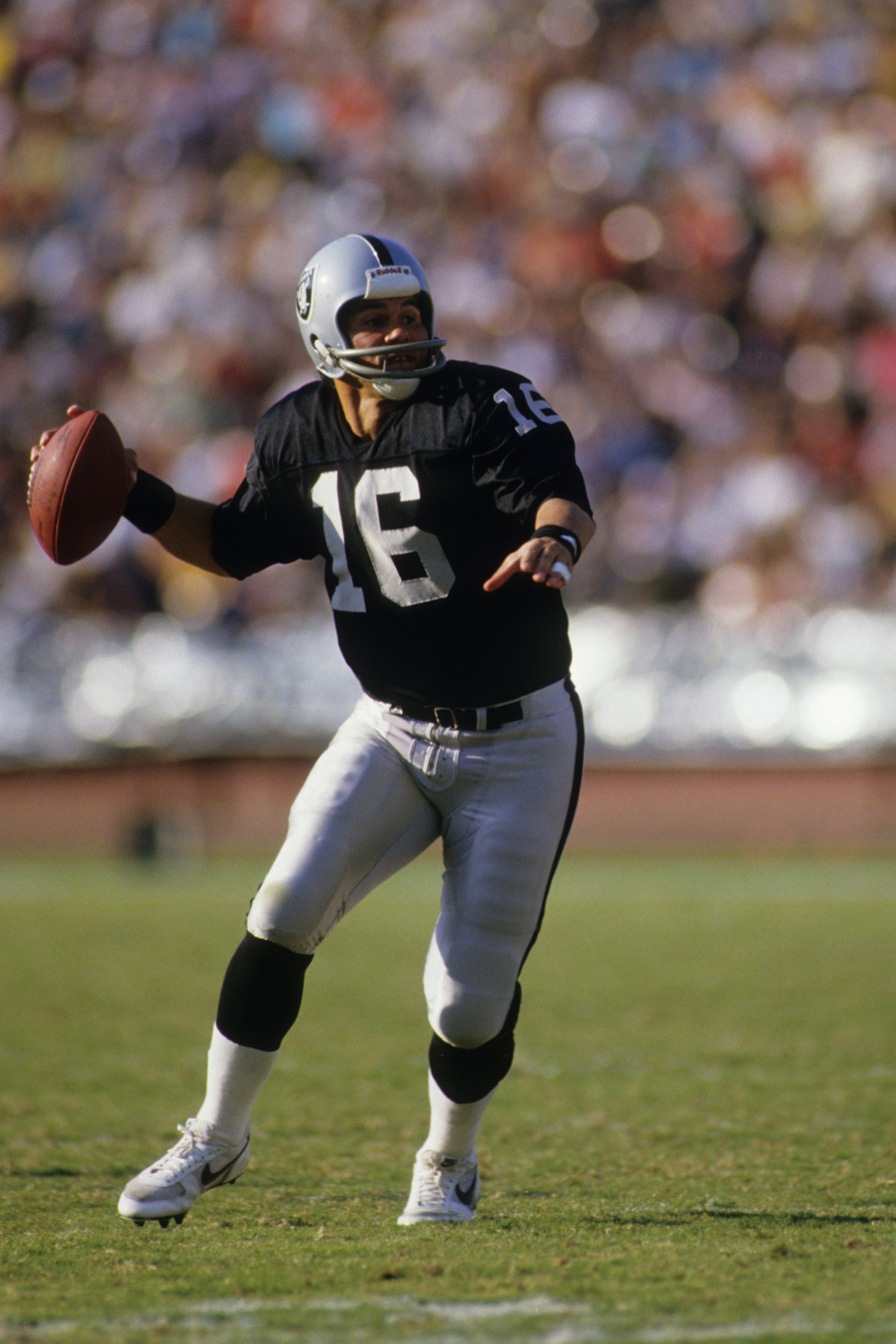 LOS ANGELES - NOVEMBER 30:  Quarterback Jim Plunkett #16 of the Los Angeles Raiders drops back to pass during the game against the Philadelphia Eagles at the Los Angeles Memorial Coliseum on November 30, 1986 in Los Angeles, California.  The Eagles won 33