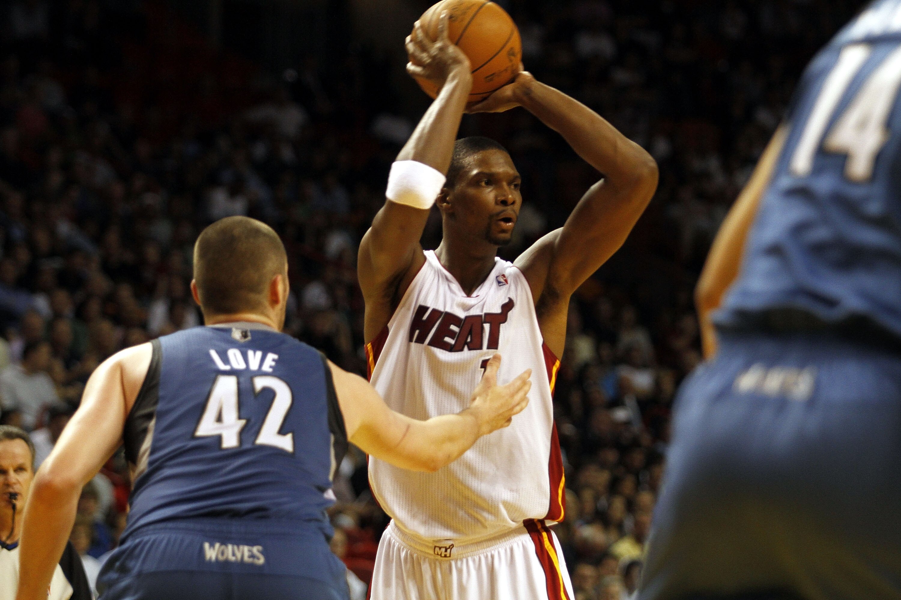 MIAMI - NOVEMBER 02:  Forward Chris Bosh #1 of the Miami Heat passes against center Kevin Love #42 of the Minnesota Wolves at American Airlines Arena on November 2, 2010 in Miami, Florida. NOTE TO USER: User expressly acknowledges and agrees that, by down