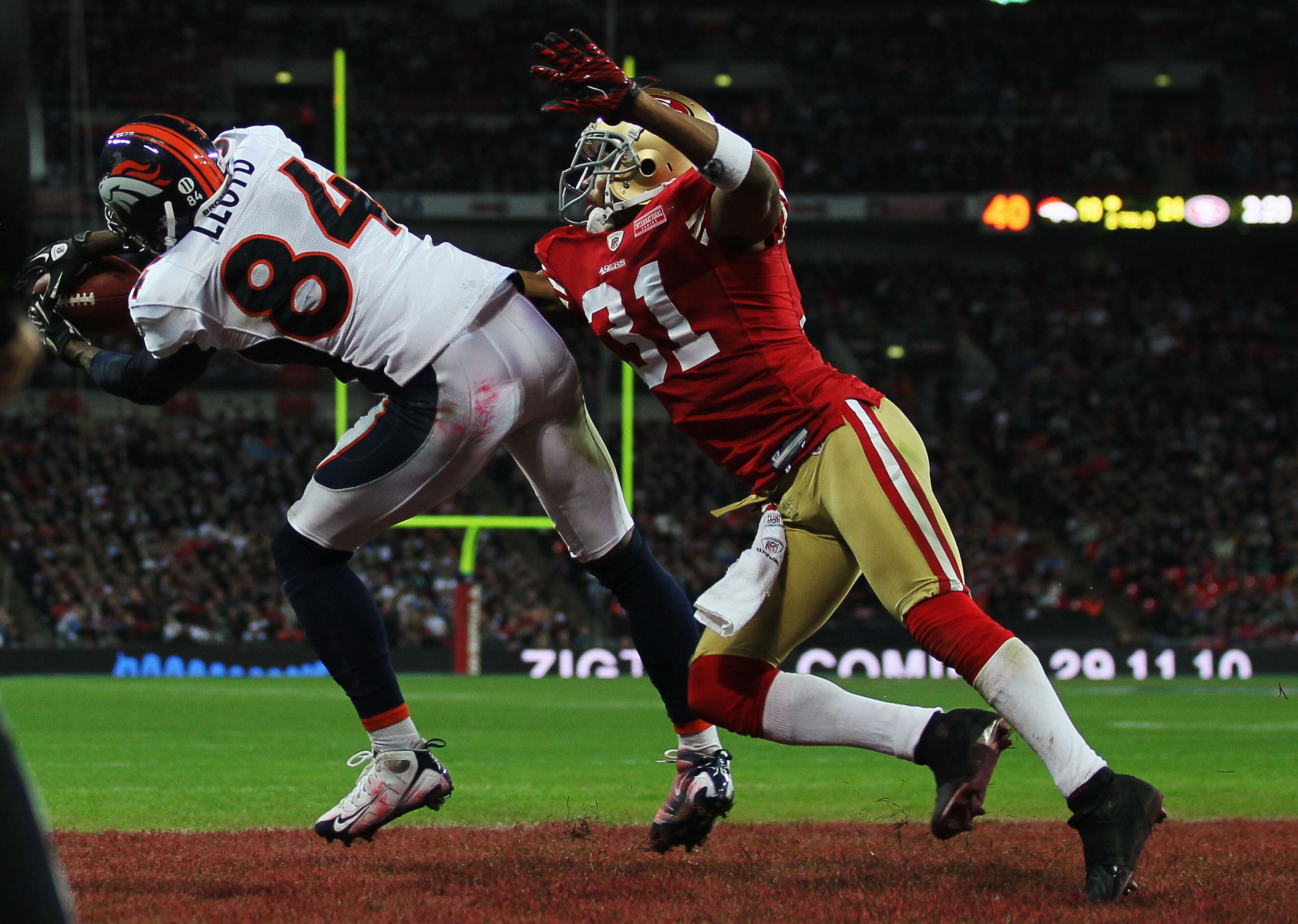 LONDON, ENGLAND - OCTOBER 31:  Brandon Lloyd #84 of Denver Broncos beats William James #31 of San Francisco 49ers to the ball as he scores their second touchdown during the NFL International Series match between Denver Broncos and San Francisco 49ers at W