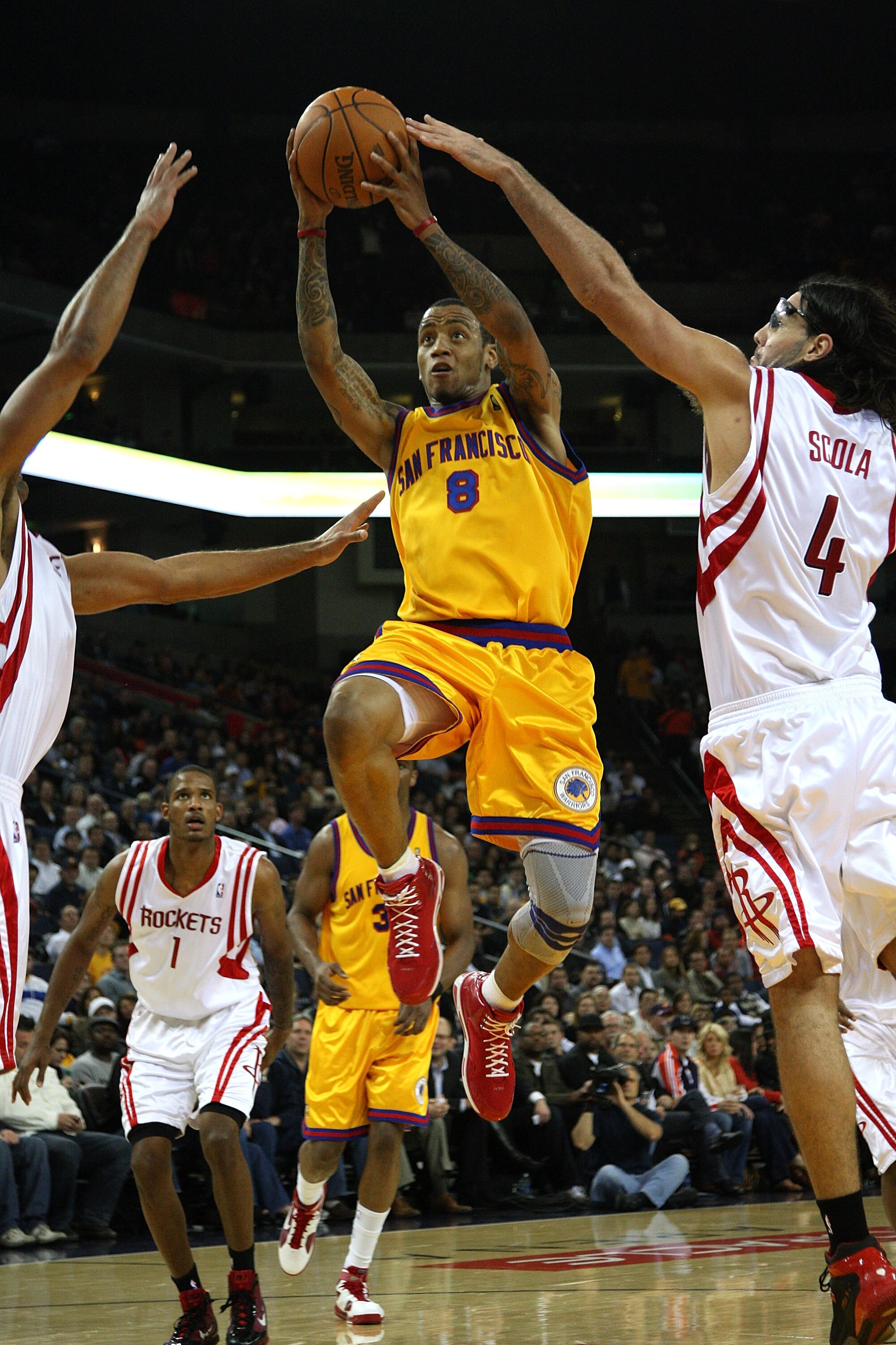 OAKLAND, CA - DECEMBER 03:  Monta Ellis #8 of the Golden State Warriors drives against Luis Scola #4 of the Houston Rockets during an NBA game at Oracle Arena on December 3, 2009 in Oakland, California. NOTE TO USER: User expressly acknowledges and agrees