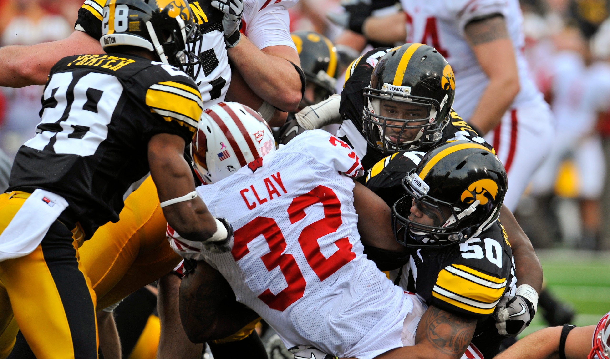 IOWA CITY, IA - OCTOBER 23: Running back John Clay #32 of the Wisconsin Badgers breaks the goal line for a touch down as defensive back Shaun Prater #28, defensive lineman Mike Daniels #93, and line backer Lance Tillison #50 of the University of Iowa Hawk
