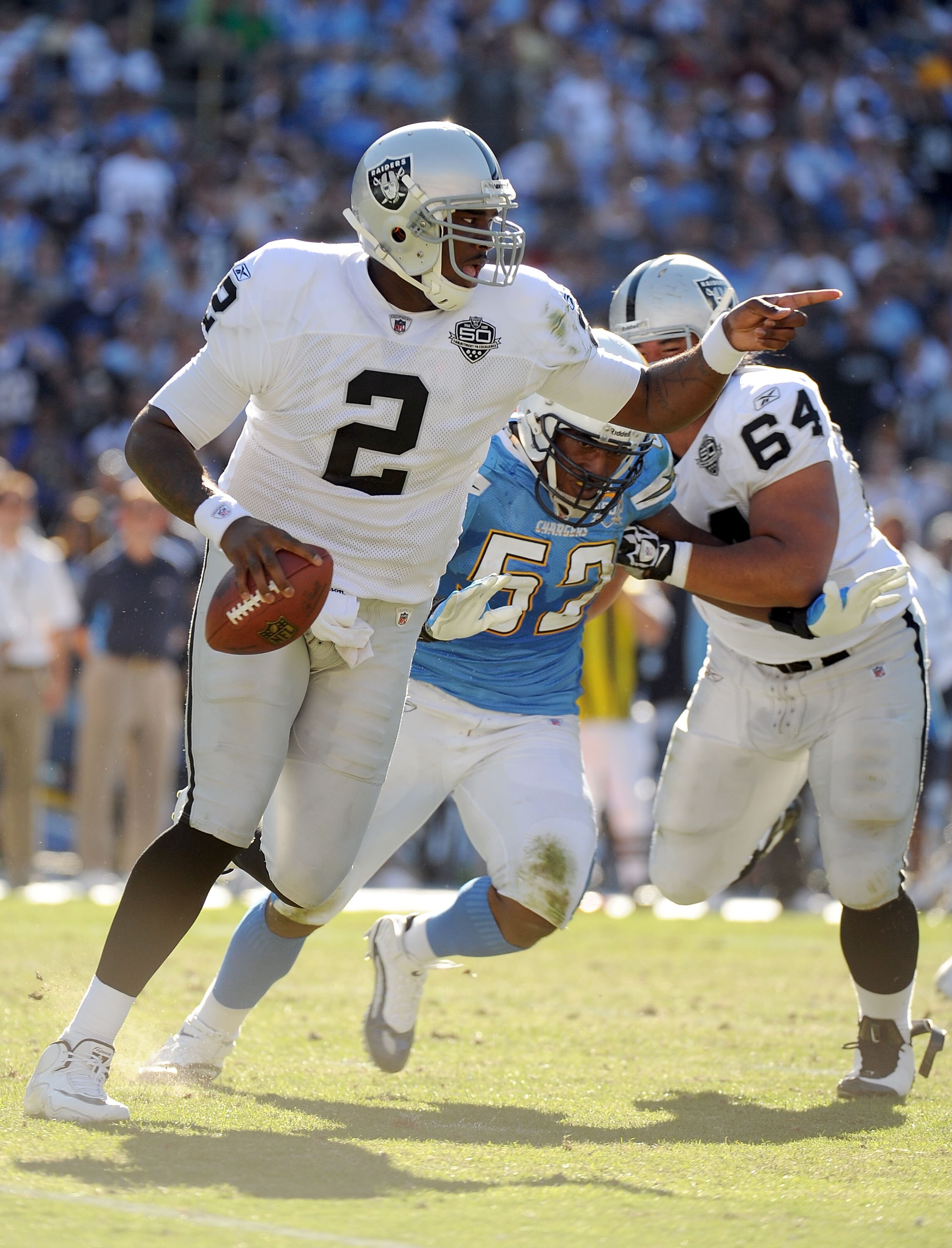 SAN DIEGO - NOVEMBER 01:  JaMarcus Russell #2 of the Oakland Raiders scrambles out of the pocket as he is rushed by Larry Engllish #52 of the San Diego Chargers during the second quarter at Qualcomm Stadium on November 1, 2009 in San Diego California.  (P