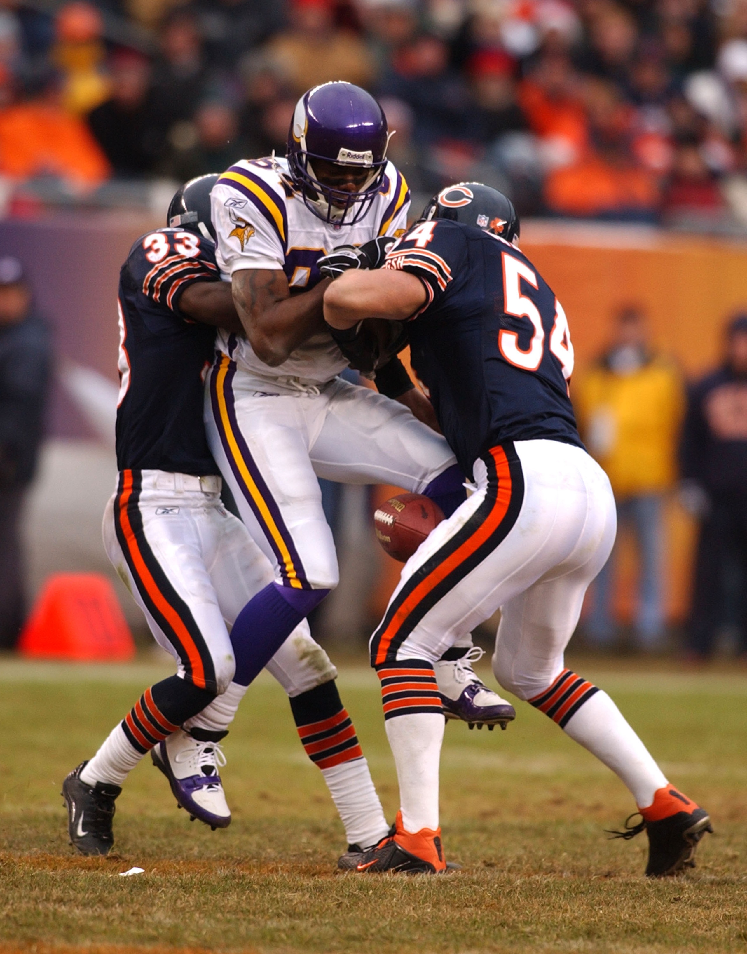 CHICAGO - DECEMBER 14: Receiver Randy Moss #84 of the Minnesota Vikings is hit and drops the ball by linebacker Brian Urlacher #54 and cornerback Charles Tillman #33 of the Chicago Bears during a game on December 14, 2003 at Soldier Field in Chicago, Illi