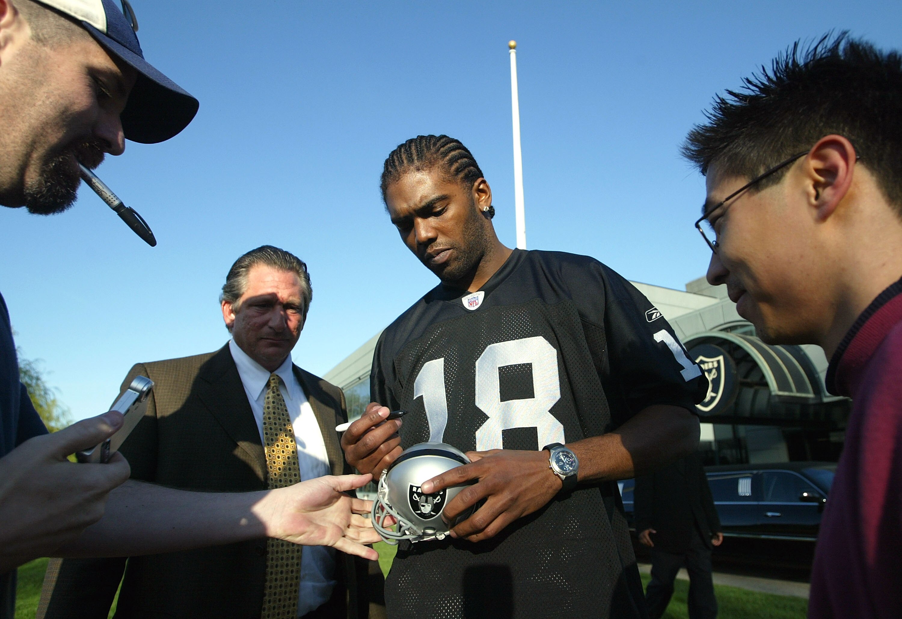 ALAMEDA, CA - MARCH 02:  New Oakland Raiders wide receiver Randy Moss #18 signs autographs after speaking at a news conference March 2, 2005 in Alameda, California. The former Minnesota Vikings was introduced by his new team today and the Raiders are work