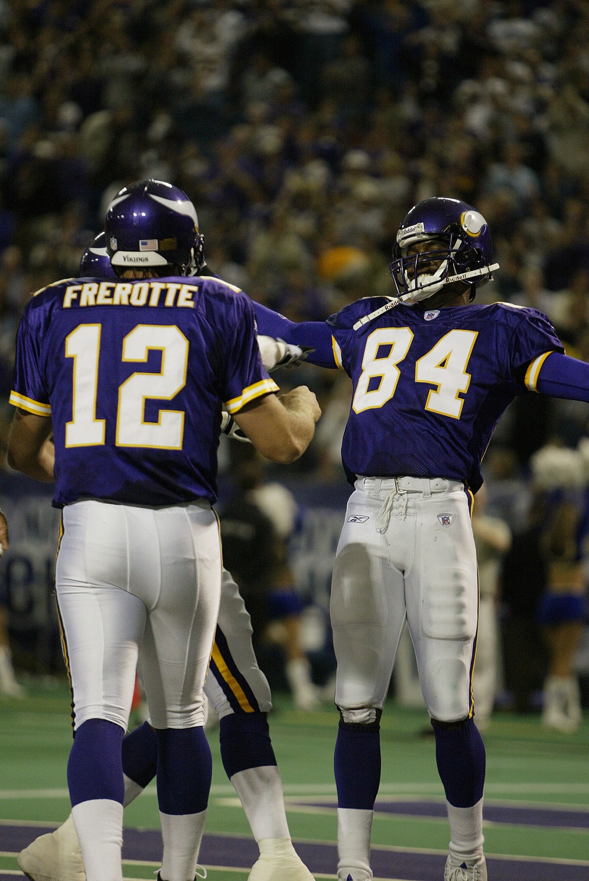 MINNEAPOLIS - SEPTEMBER 28:  Wide receiver Randy Moss #84 and quarterback Gus Frerotte #12 of the Minnesota Vikings celebrate a touchdown in the first half against the San Francisco 49ers at the Hubert H. Humphrey Metrodome on September 28, 2003 in Minnea