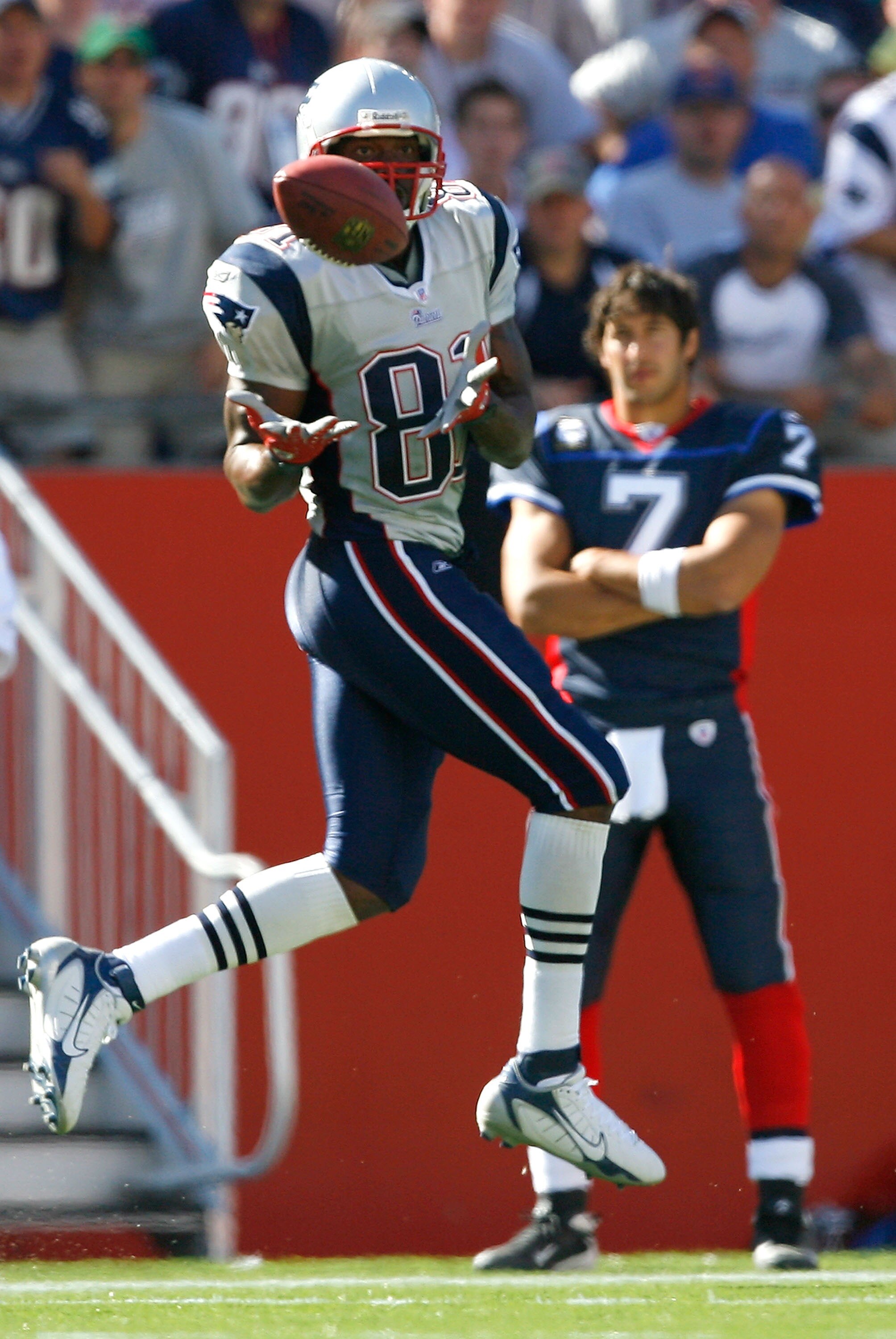 FOXBORO, MA - SEPTEMBER 23: Randy Moss #81 of the New England Patriots grabs a pass as JP Losman #7 of the Buffalo Bills watches from the sideline at Gillette Stadium on September 23, 2007 in Foxboro, Massachusetts. The Patriots defeated the Bills 38-7.  