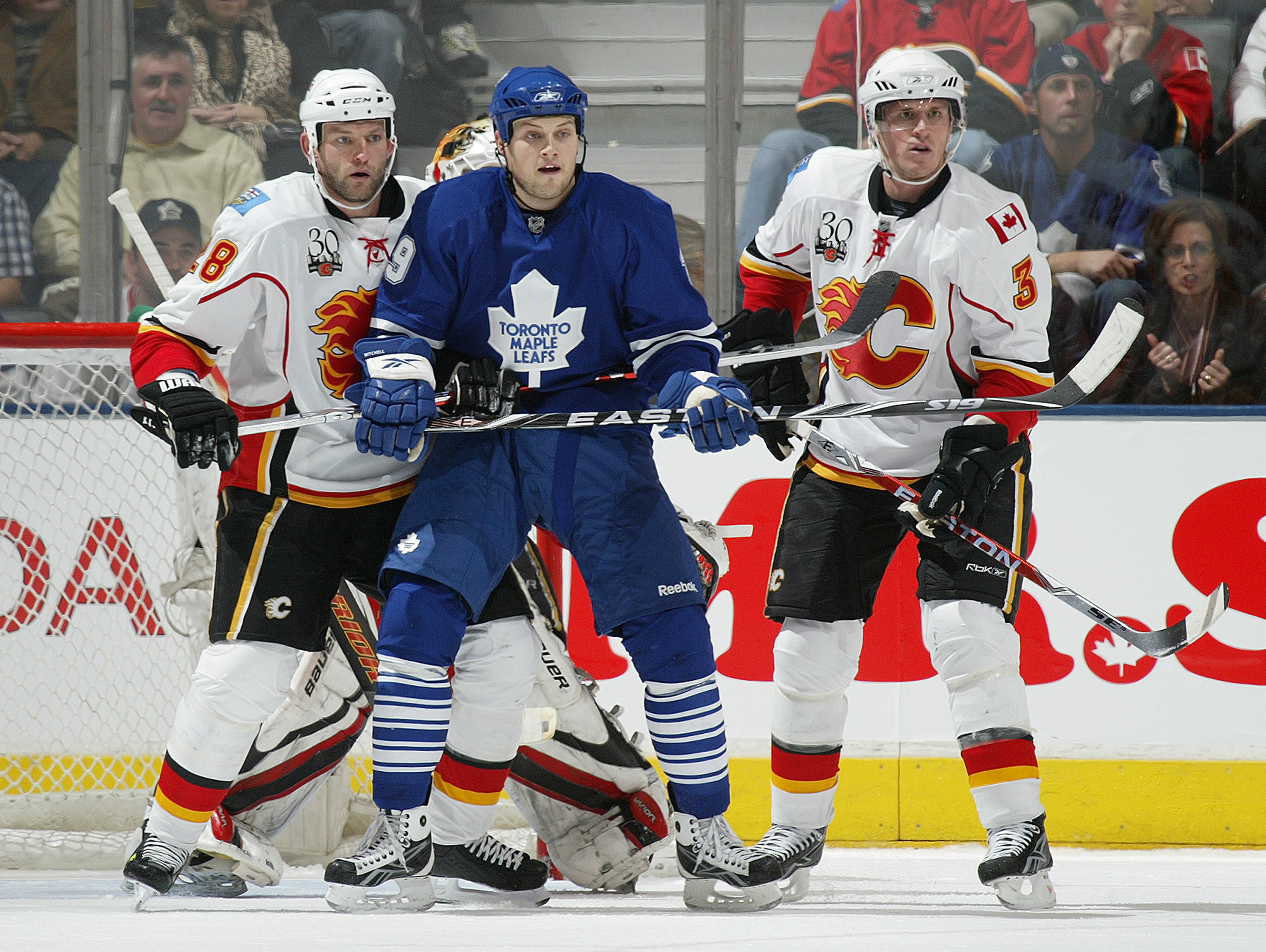 TORONTO, ON - NOVEMBER 14:  John Mitchell #39 of the Toronto Maple Leafs looks to deflect a shot between Robyn Regehr #28 and Dion Phaneuf #3 of the Calgary Flames in a game on November 14, 2009 at the Air Canada Centre in Toronto, Ontario, Canada.  (Phot
