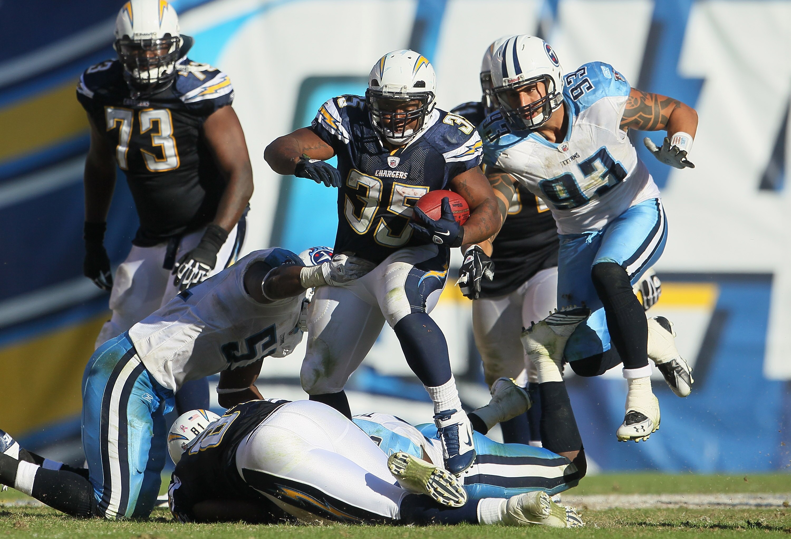 SAN DIEGO - OCTOBER 31:  Running back Mike Tolbert #35 of the San Diego Chargers carries the ball while being pursued by Jason Babin #93 of the Tennessee Titans in the fourth quarter at Qualcomm Stadium on October 31, 2010 in San Diego, California. The Ch