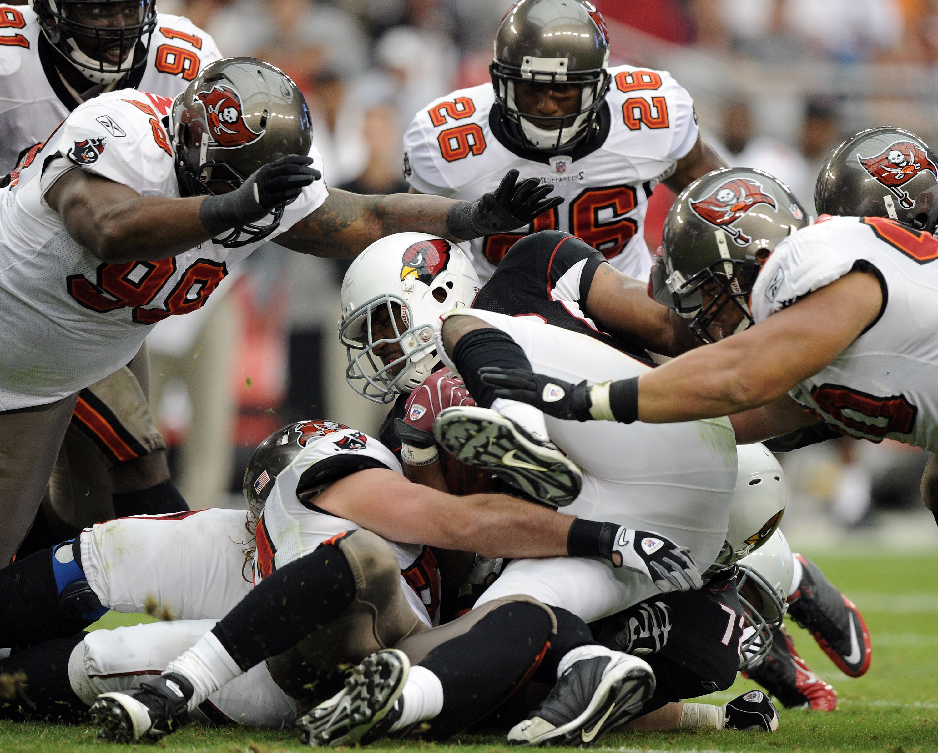 GLENDALE, AZ - OCTOBER 31:  Beanie Wells #26 of the Arizona Cardinals is tackled by Roy Miller #90, Ryan Sims #98 and Sean Jones #26 of the Tampa Bay Buccaneers at University of Phoenix Stadium on October 31, 2010 in Glendale, Arizona.  (Photo by Harry Ho