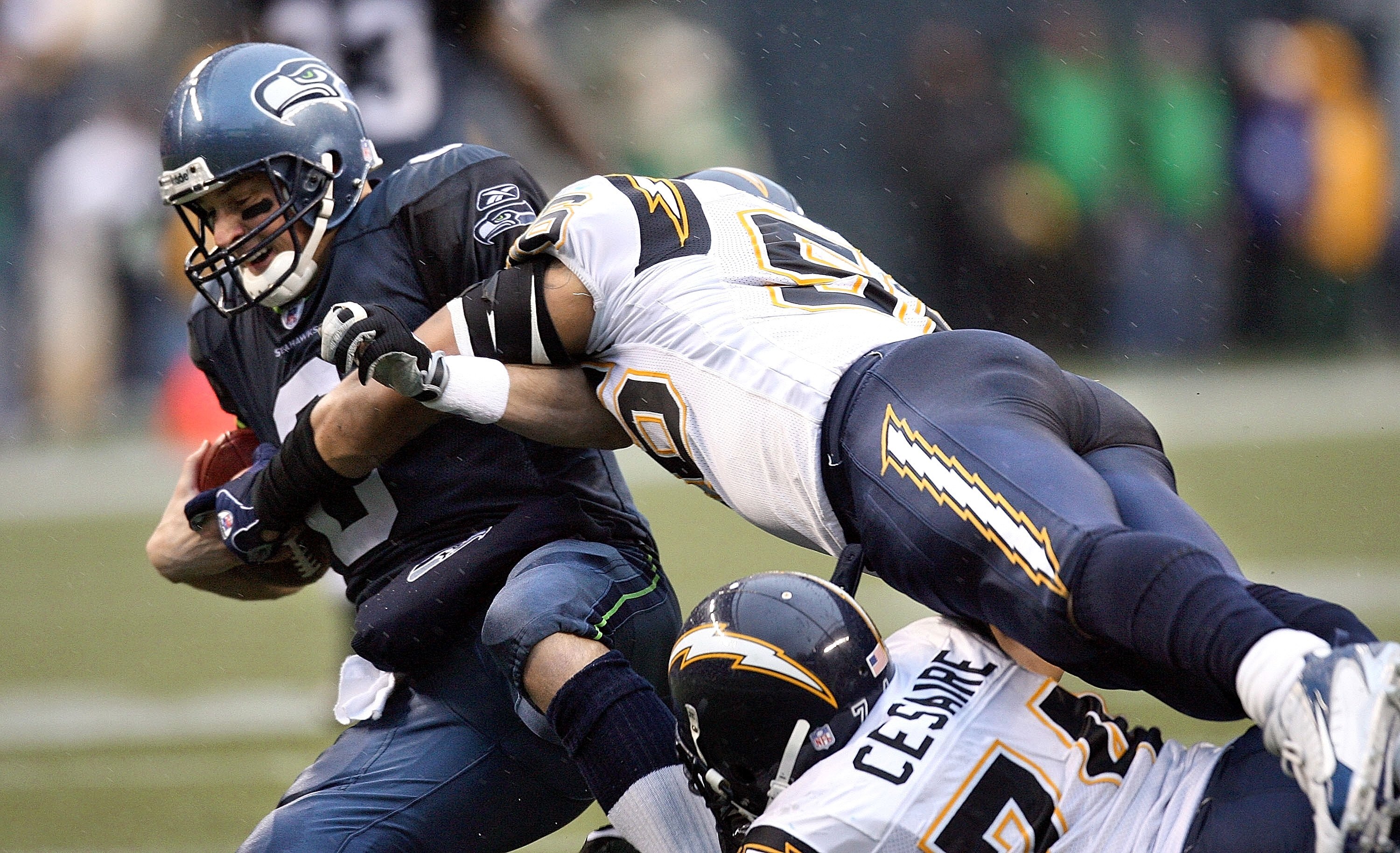 SEATTLE - DECEMBER 24:  Quarterback Matt Hasselbeck #8 of the Seattle Seahawks is sacked by linebacker Shawne Merriman #56 and defensive end Jacques Cesaire #74 of the San Diego Chargers on December 24, 2006 at Qwest Field in Seattle, Washington.  (Photo
