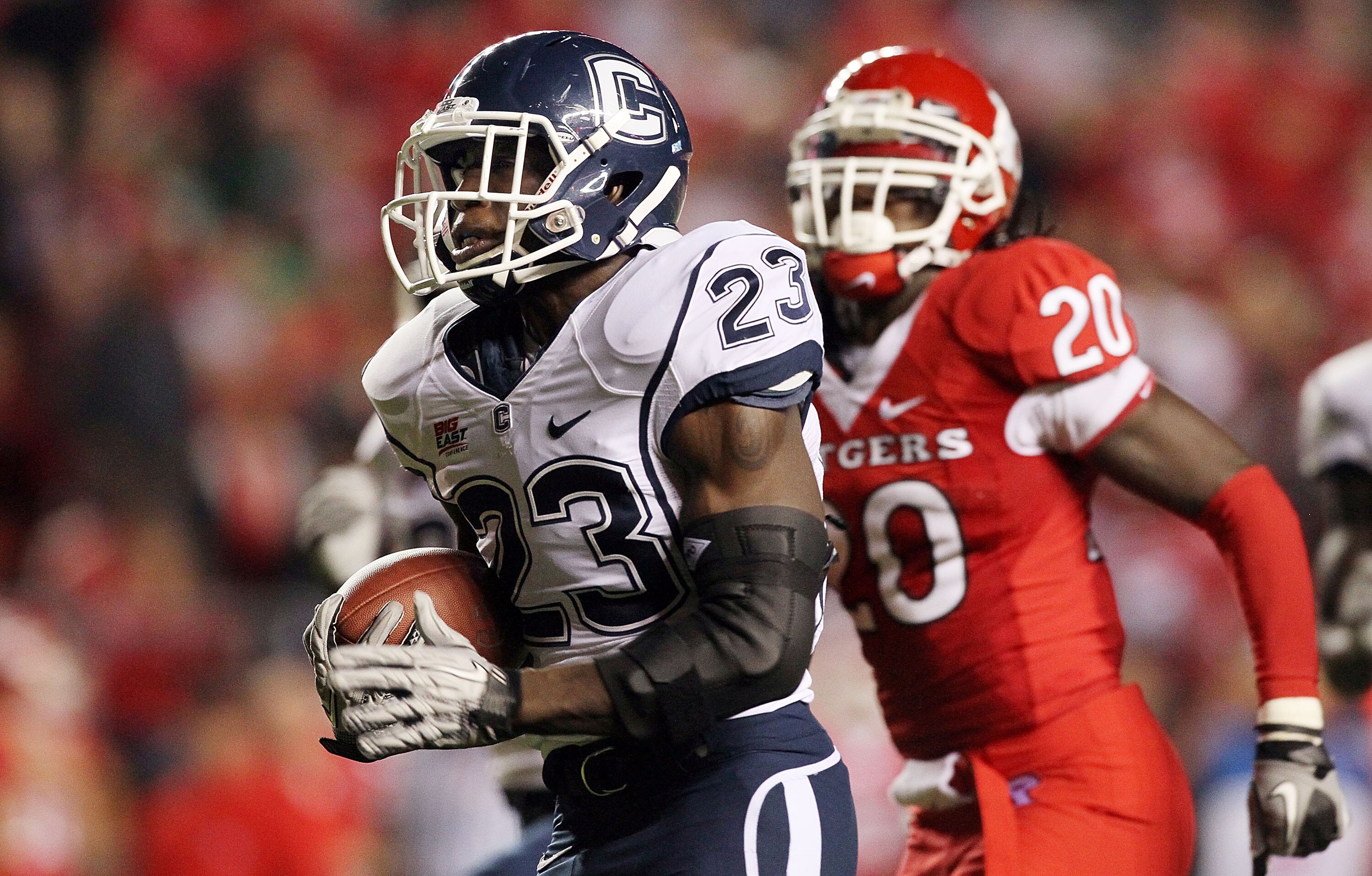 PISCATAWAY, NJ - OCTOBER 08:  Jordan Todman #23 of the Connecticut Huskies runs for a second-quarter touchdown past Khaseem Greene #20 of the Rutgers Scarlet Knights at Rutgers Stadium on October 8, 2010 in Piscataway, New Jersey.  (Photo by Jim McIsaac/G